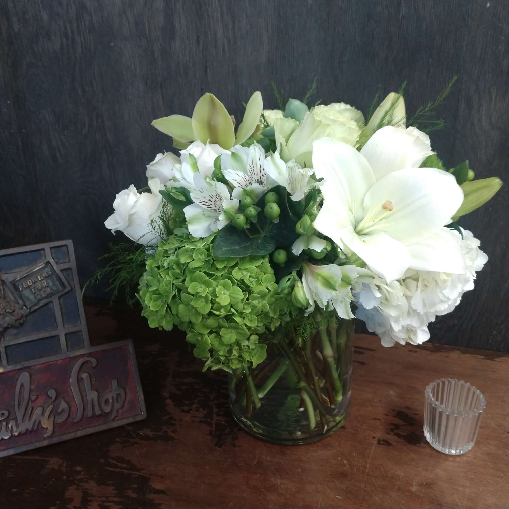 White floral arrangement in a glass vase with green blooms