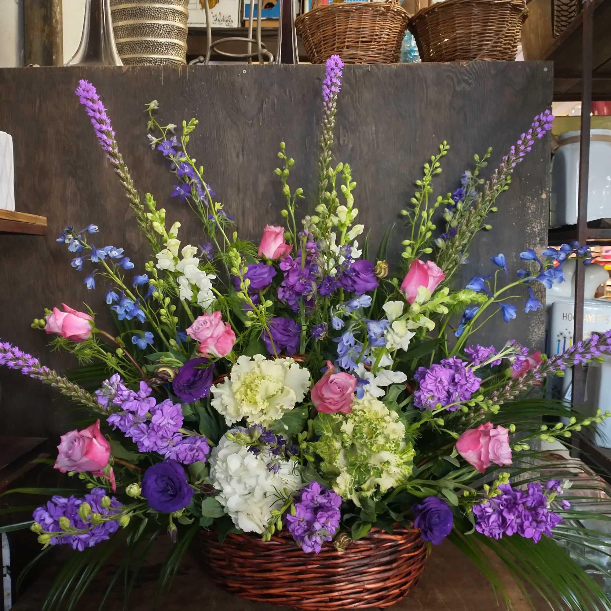 Basket arrangement of pink and purple flowers with white blooms