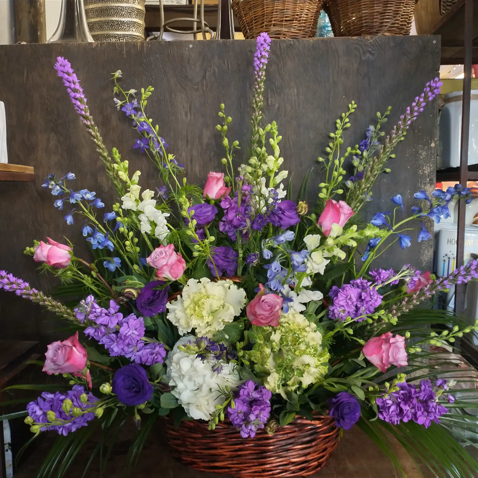 Basket arrangement of pink, purple, white, and blue flowers
