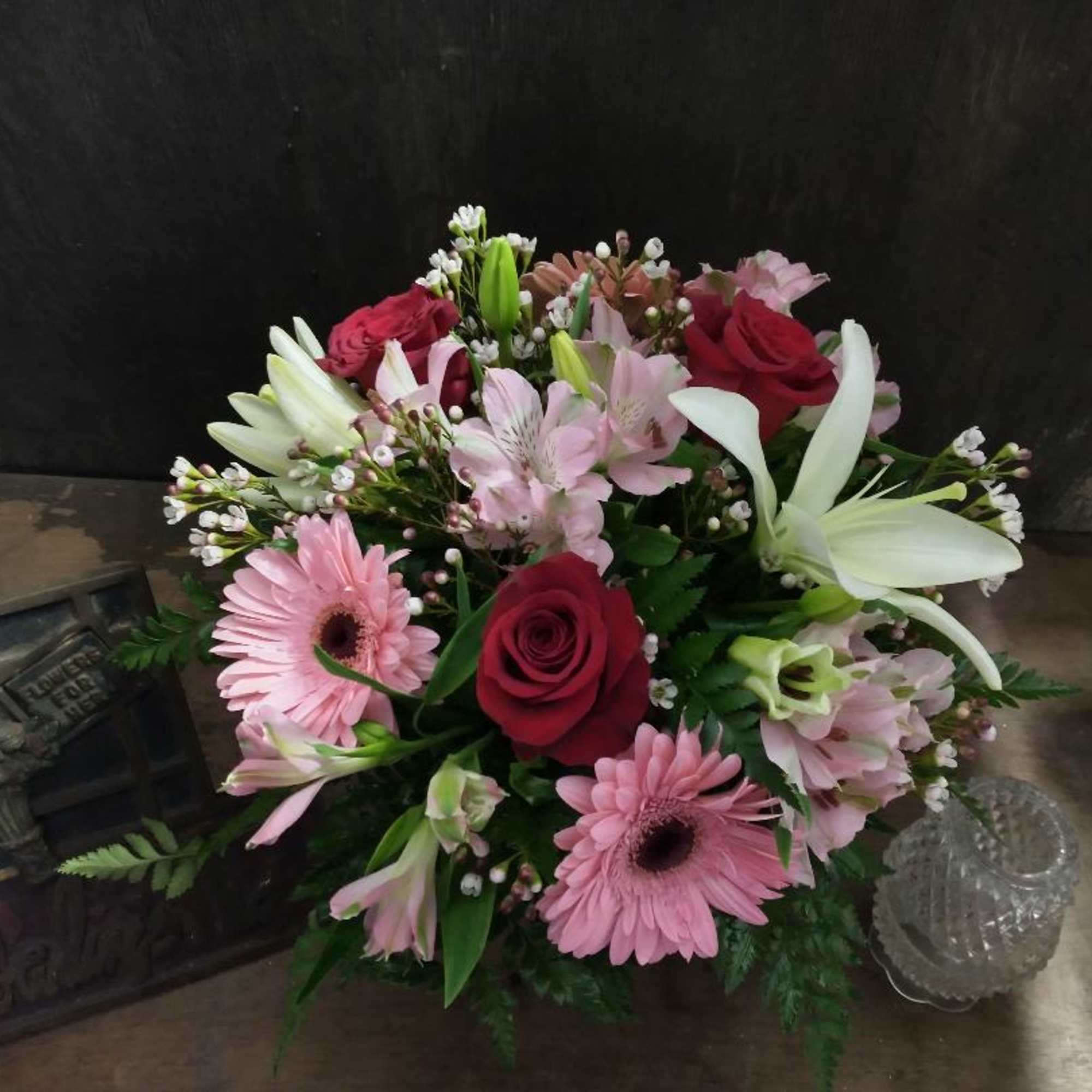 Mixed bouquet with pink gerbera daisies, red roses, and white lilies