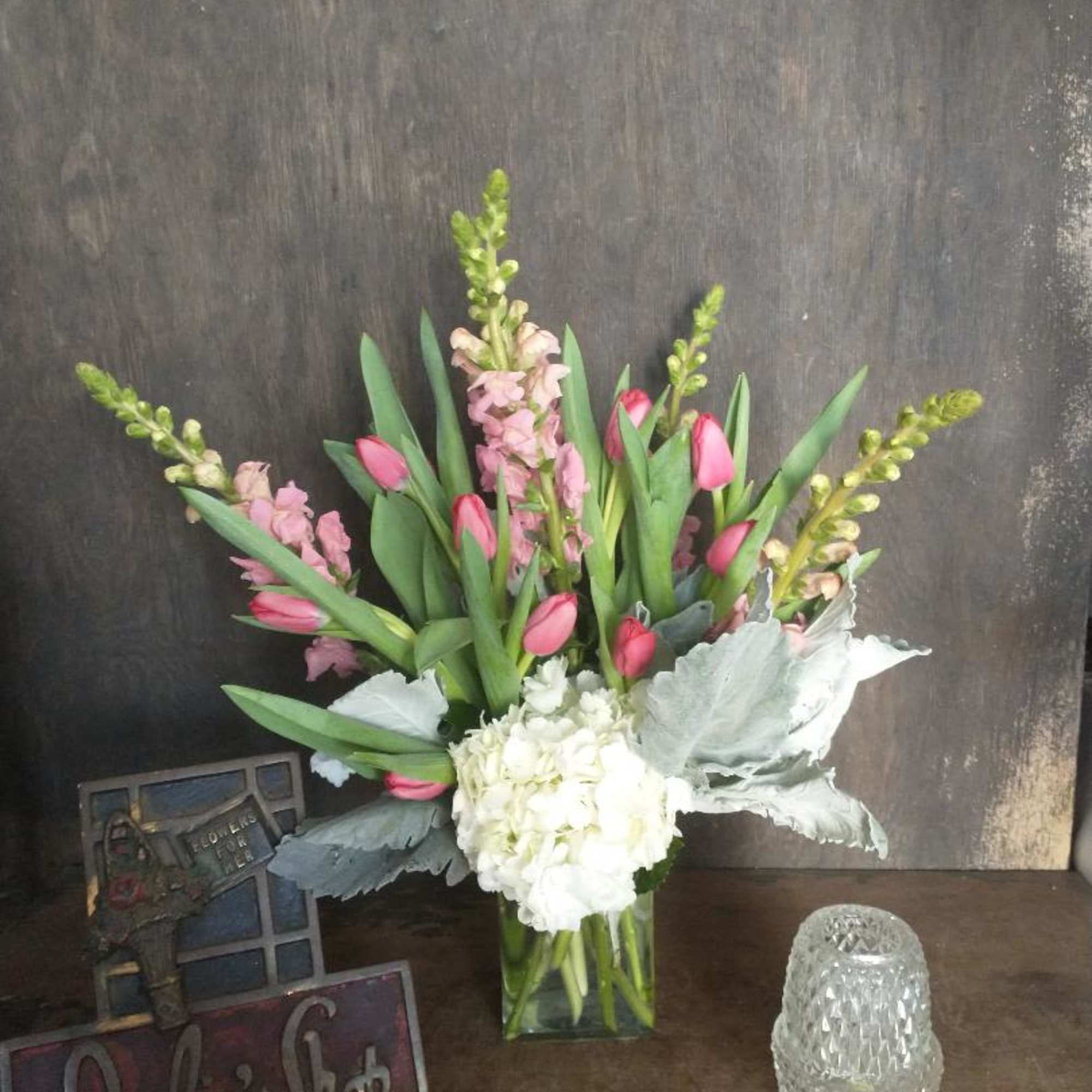 Pink tulips and white hydrangea in a clear glass vase
