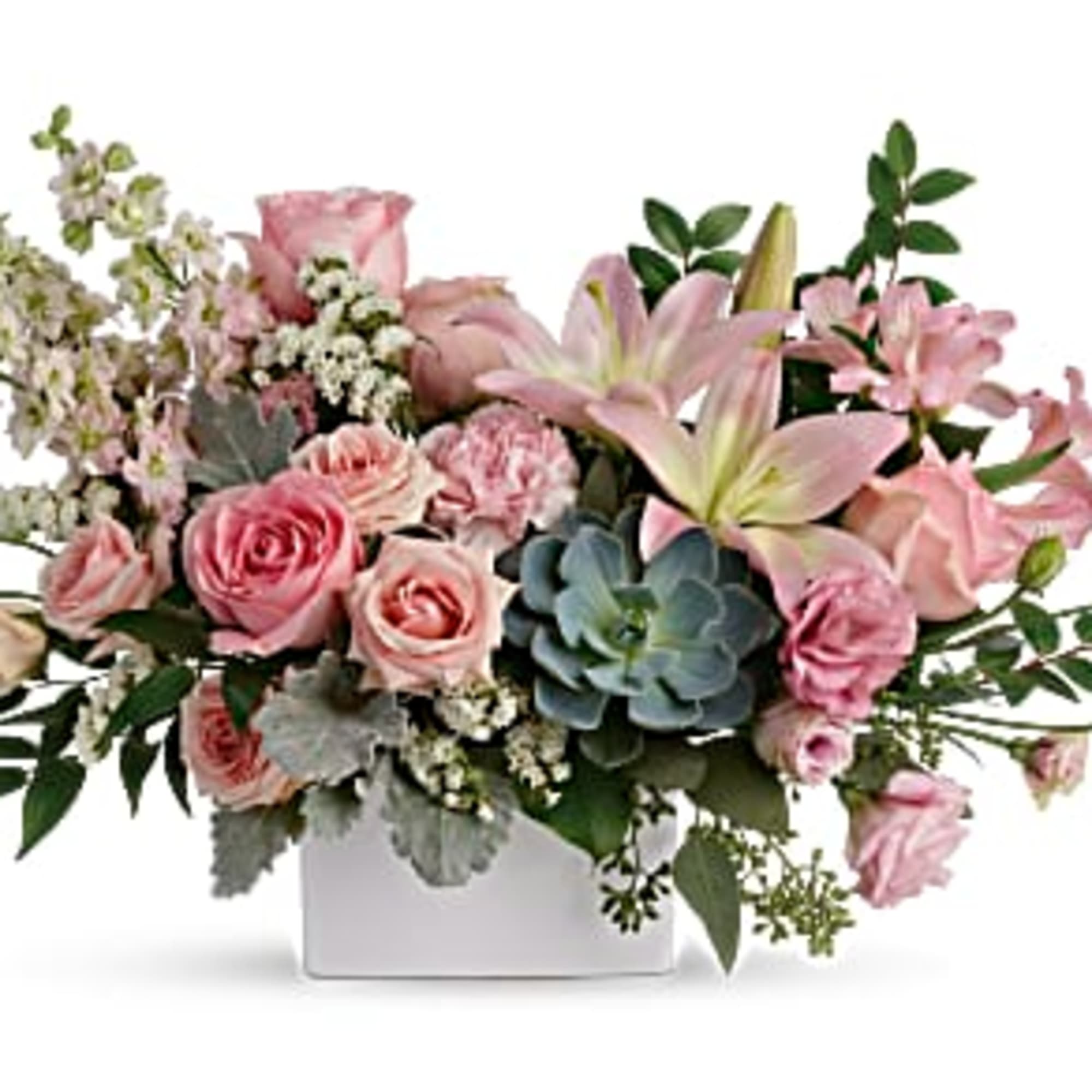 Low pastel arrangement of pink roses and lilies with a succulent in a white rectangular vase