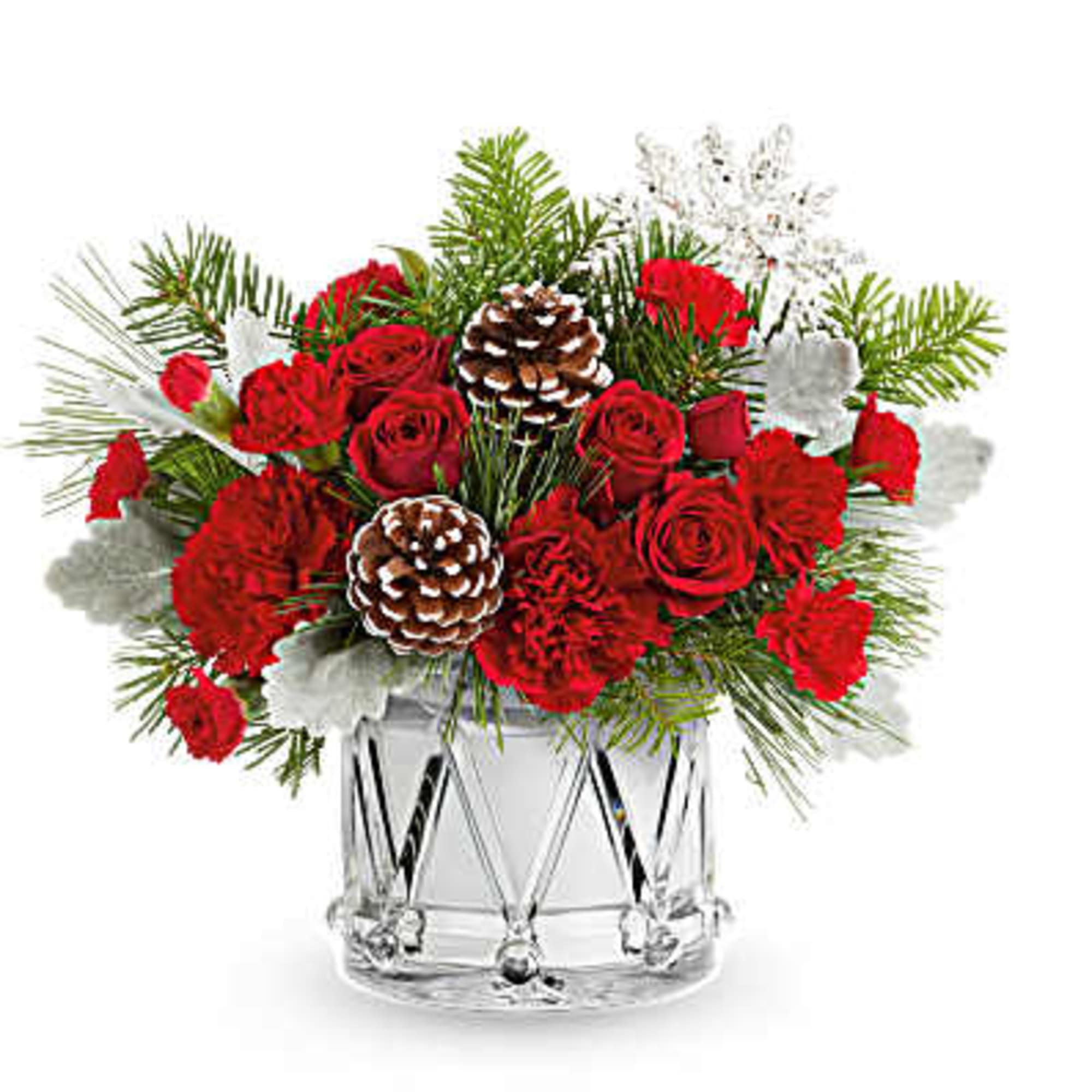 Red roses and carnations in a clear glass vase with pinecones and winter greenery