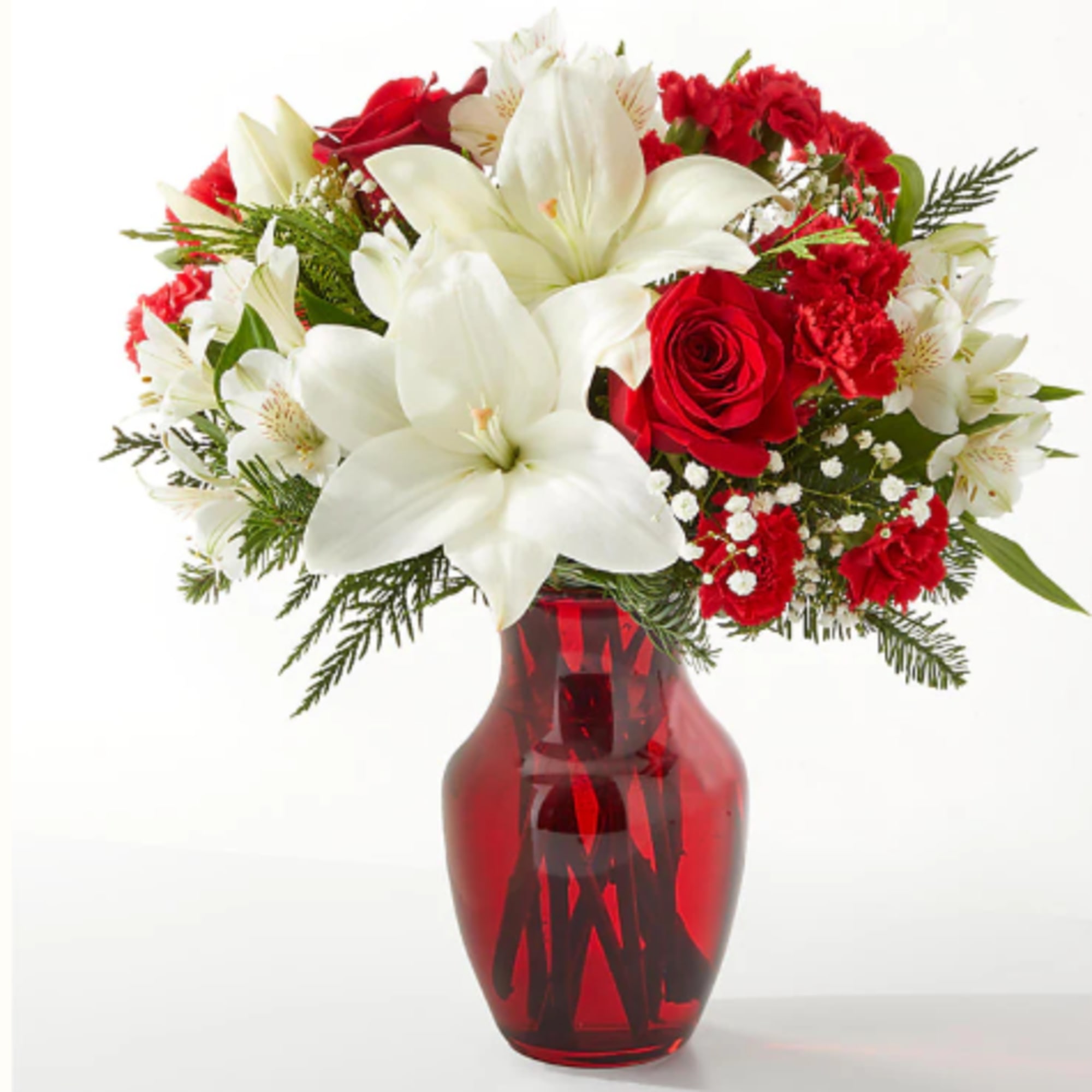 Red and white floral arrangement in a red glass vase
