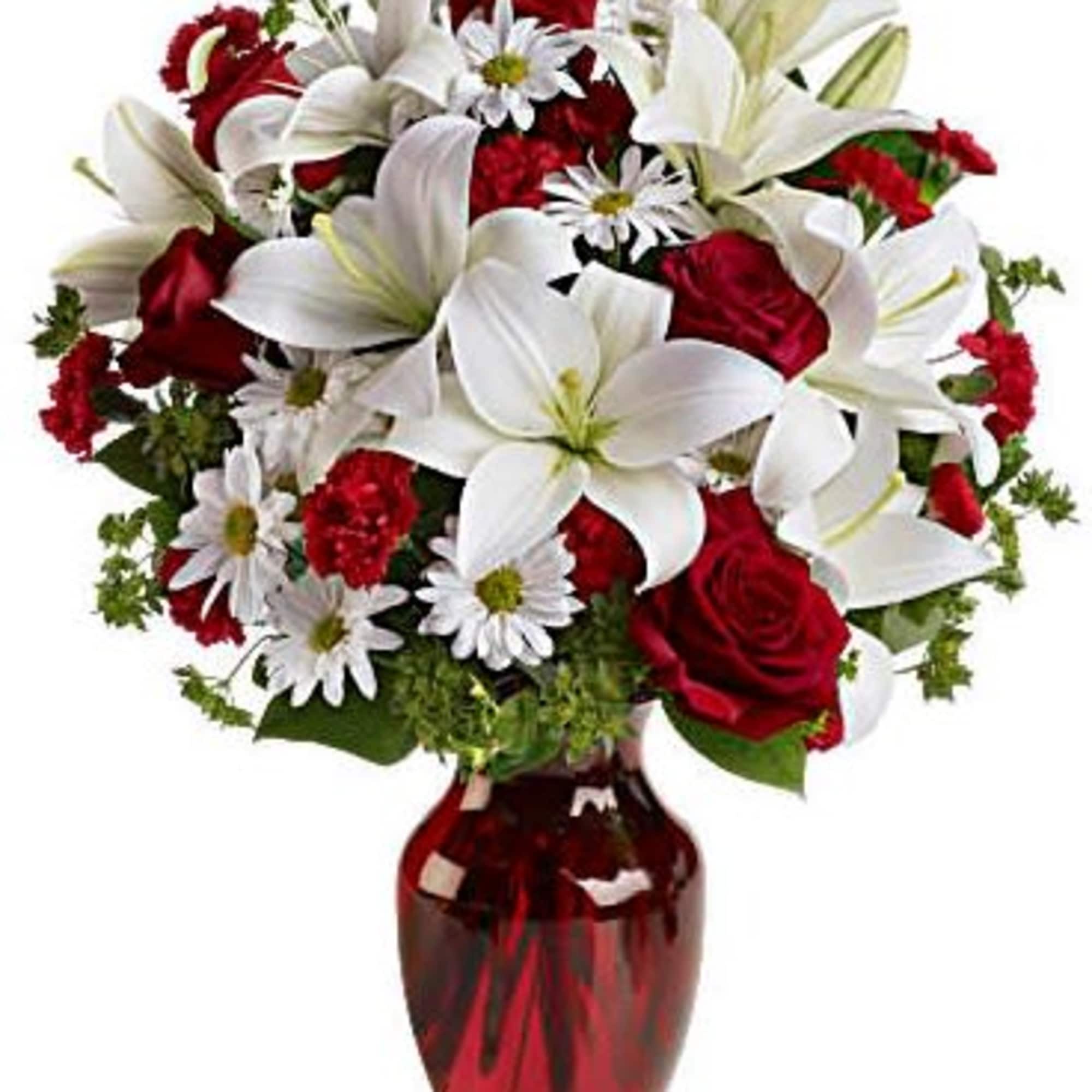 Red roses and white lilies arranged in a red glass vase