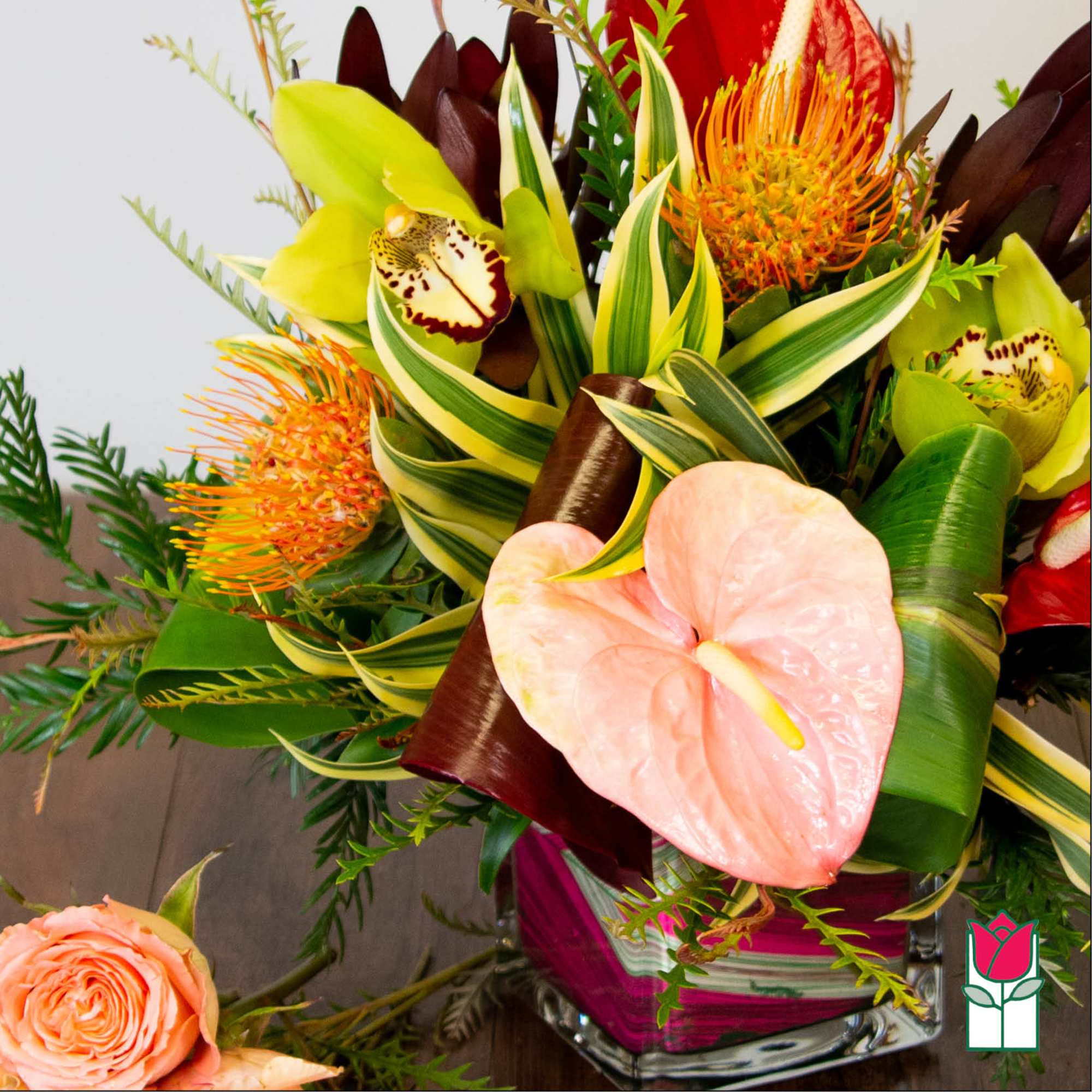 Tropical bouquet with anthurium, orchids, and orange pincushion blooms