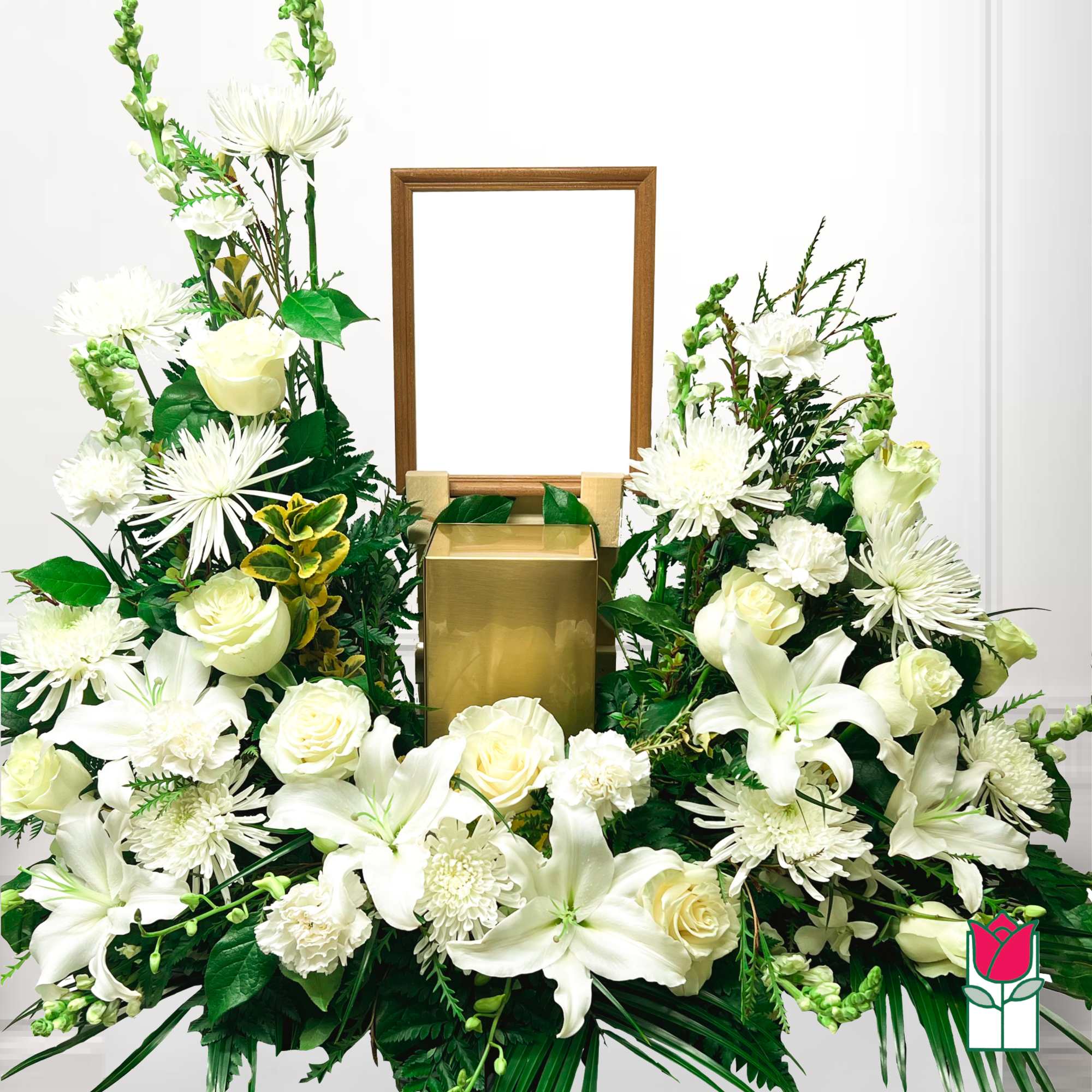 White floral funeral arrangement with lilies, roses, and chrysanthemums around a gold urn