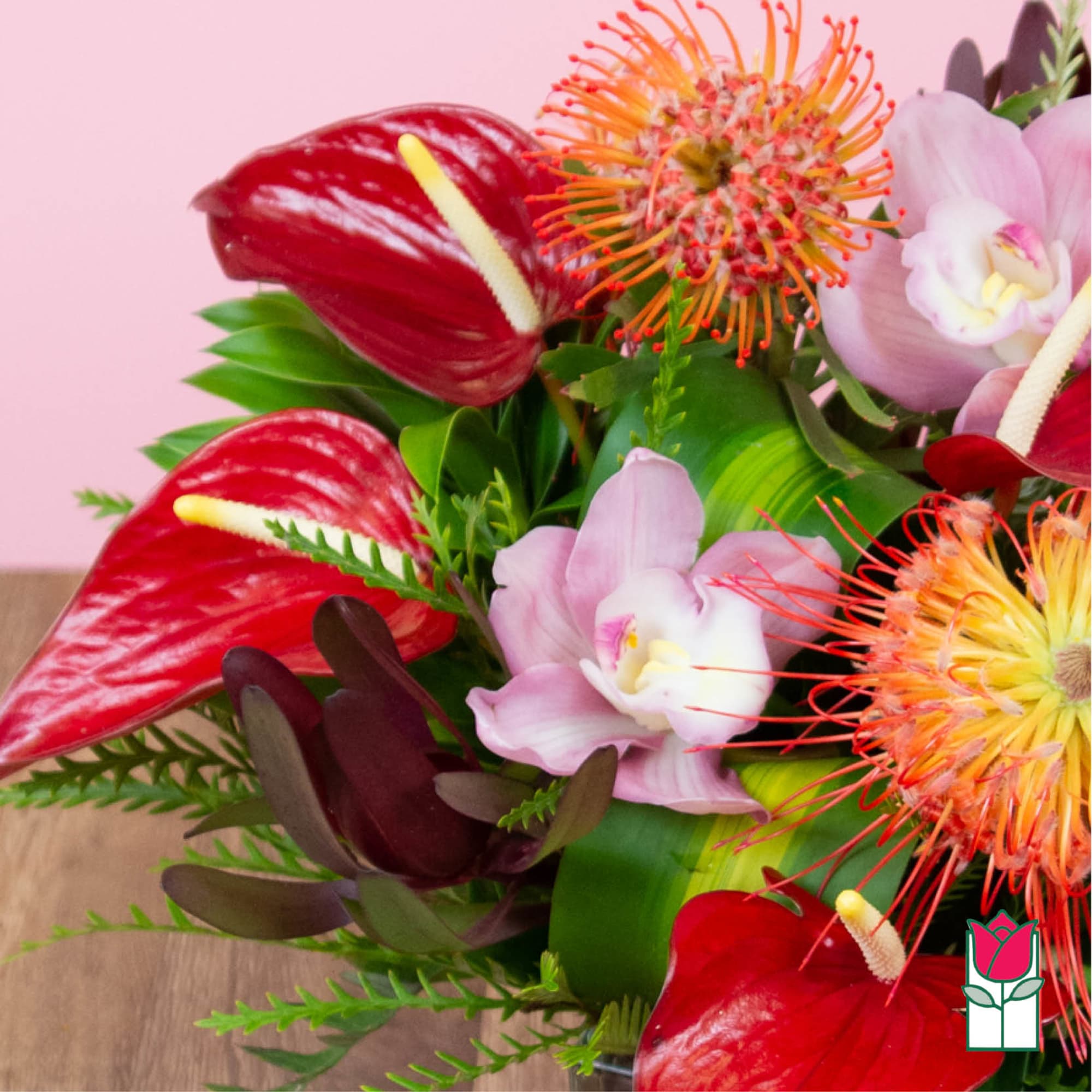 Tropical bouquet with red anthuriums, pink orchids, and orange pincushion blooms