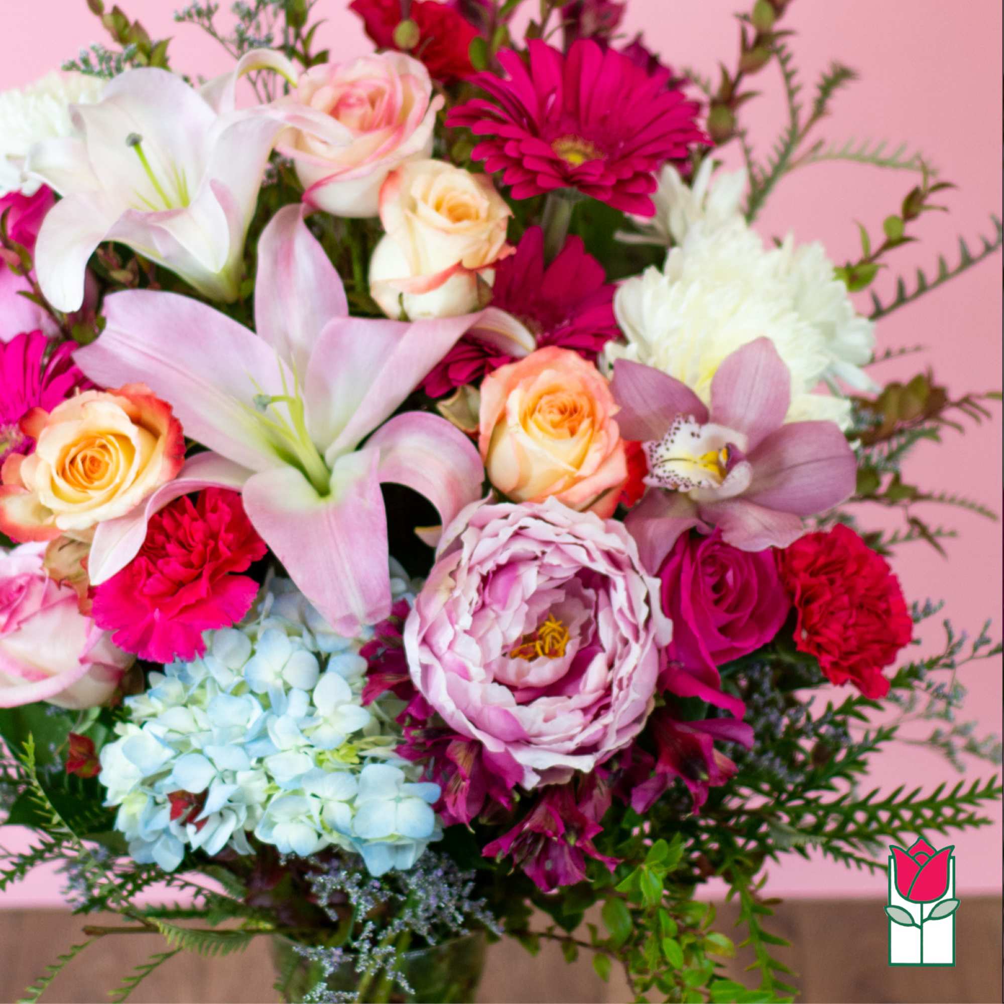 Bouquet of pink lilies, roses, and mixed blooms in a vase