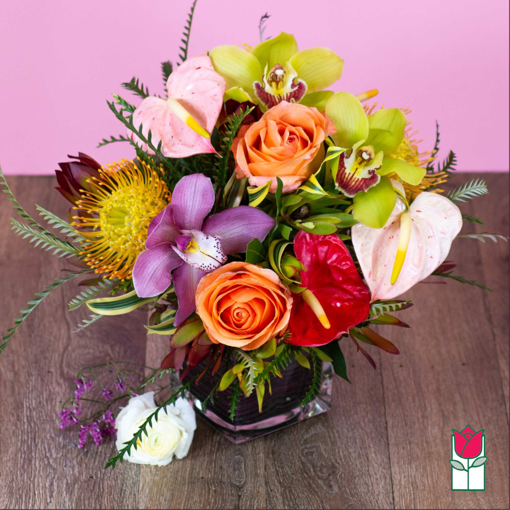 Mixed bouquet in a glass vase with roses, orchids, and anthuriums