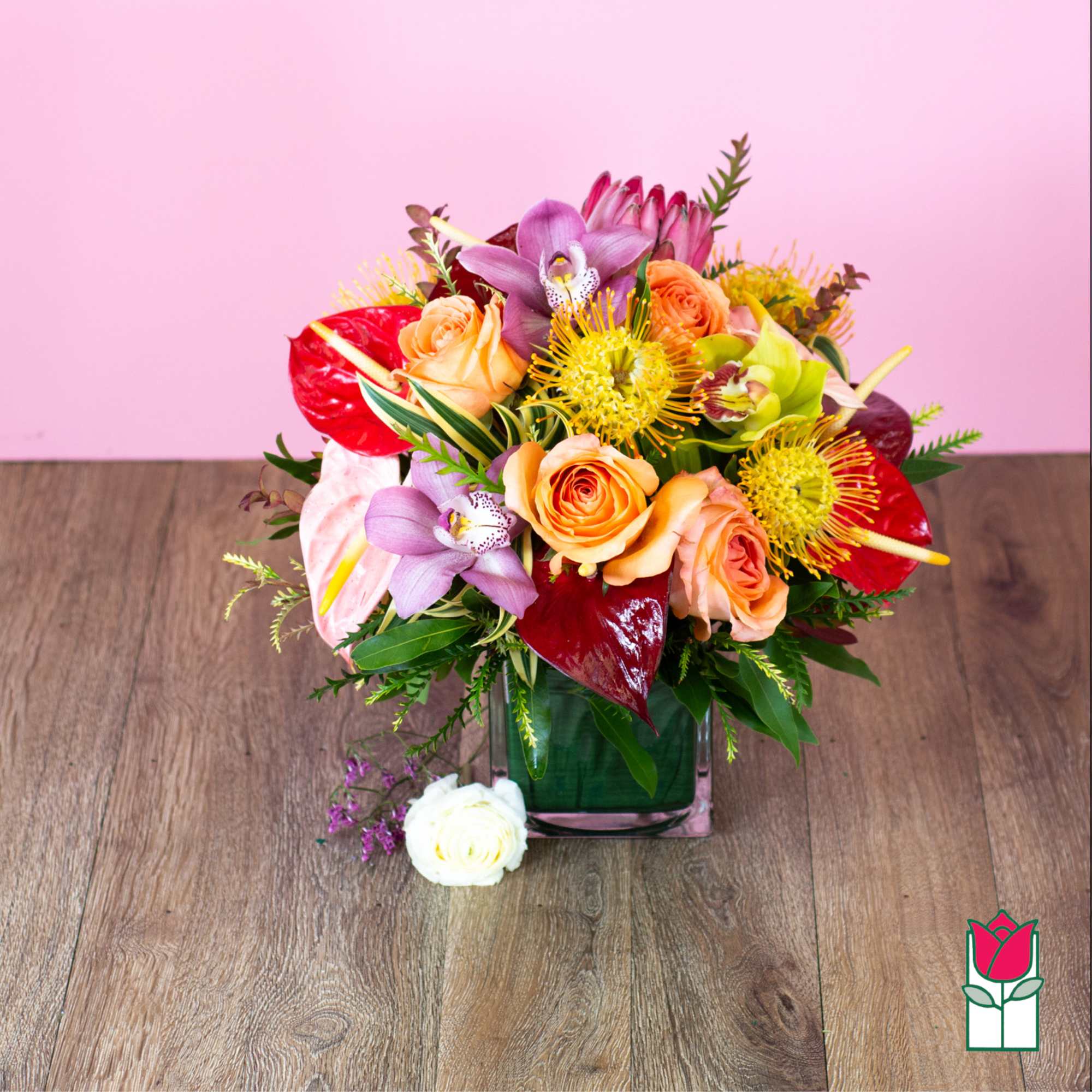 Mixed bouquet in a square glass vase with roses and orchids