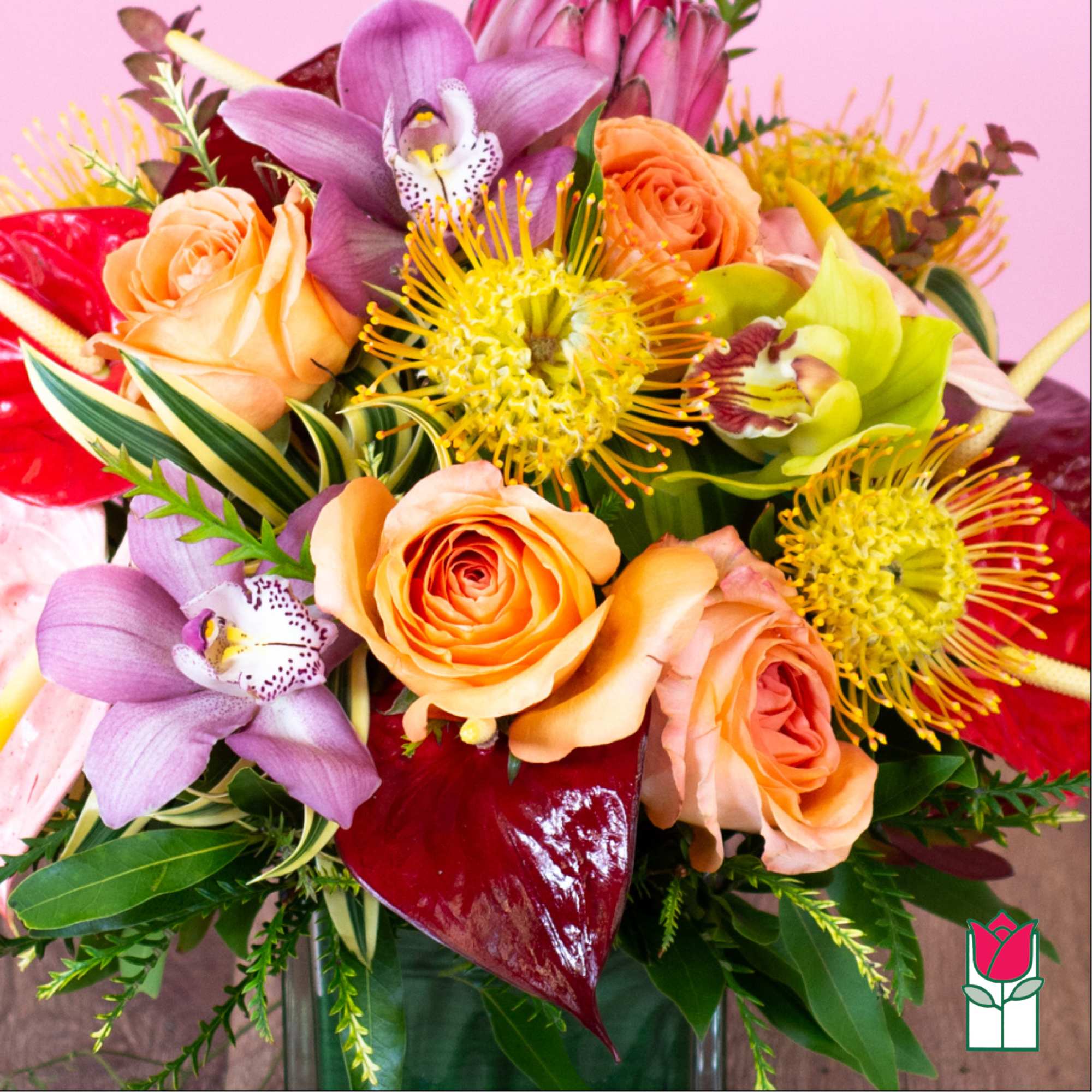Bouquet of peach roses, purple orchids, and yellow pincushion blooms in a vase