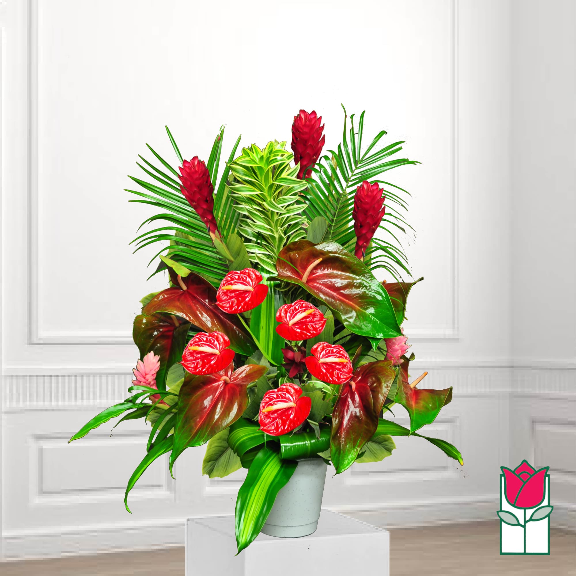 Tropical arrangement with red anthuriums and red ginger in a gray pot