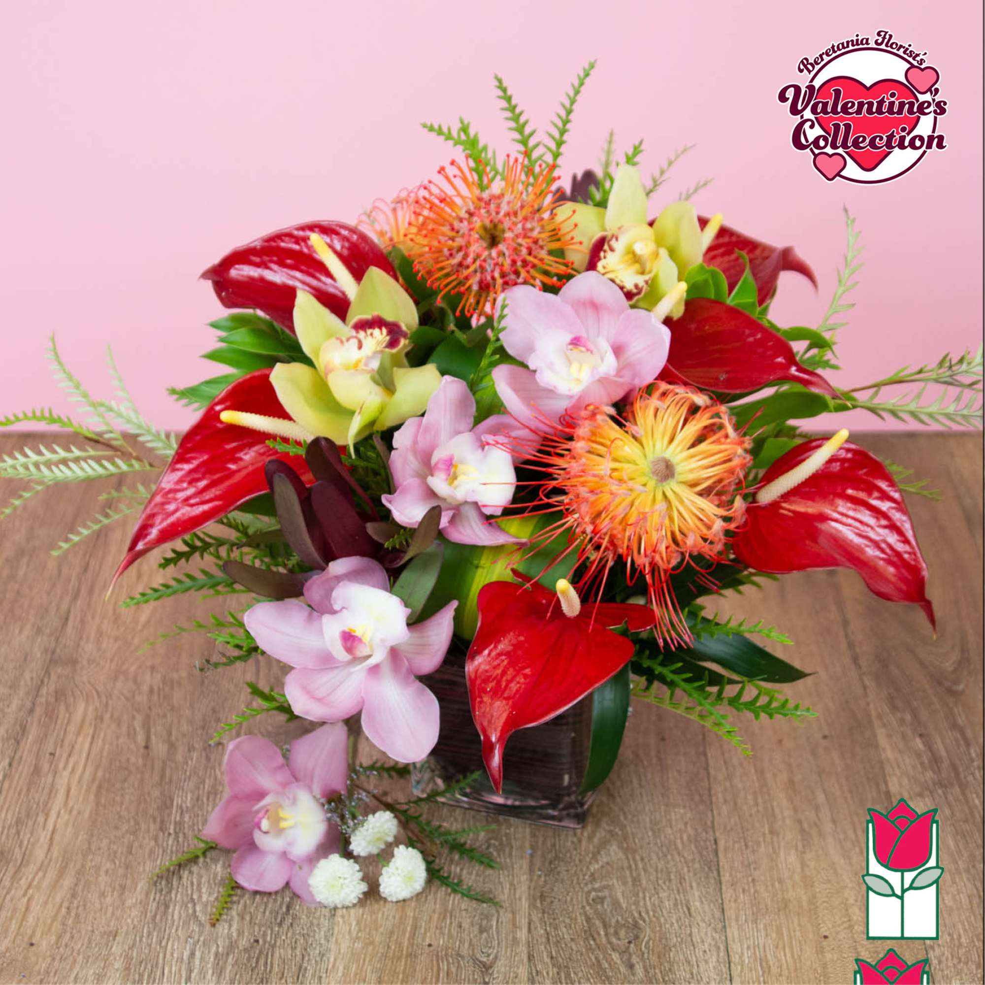 Tropical floral arrangement with red anthuriums and pink orchids in a vase