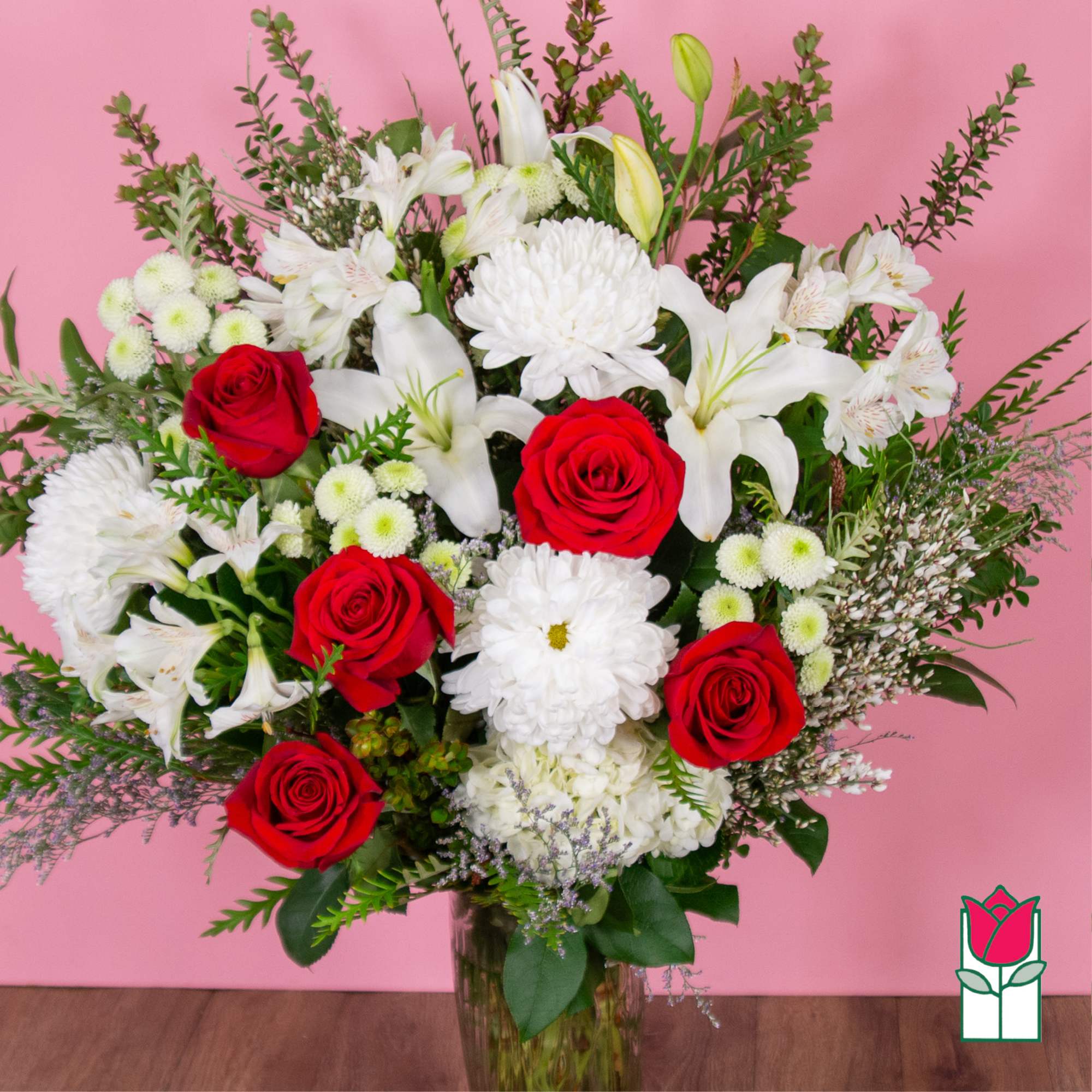 Bouquet of red roses and white lilies in a glass vase