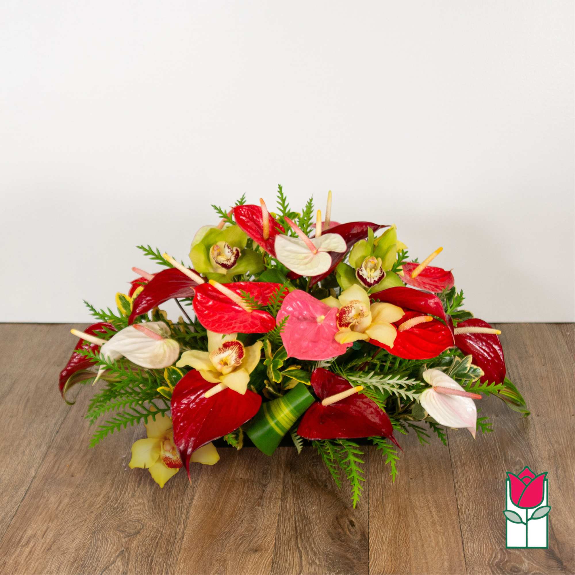 Low arrangement of red, pink, white, and yellow orchids