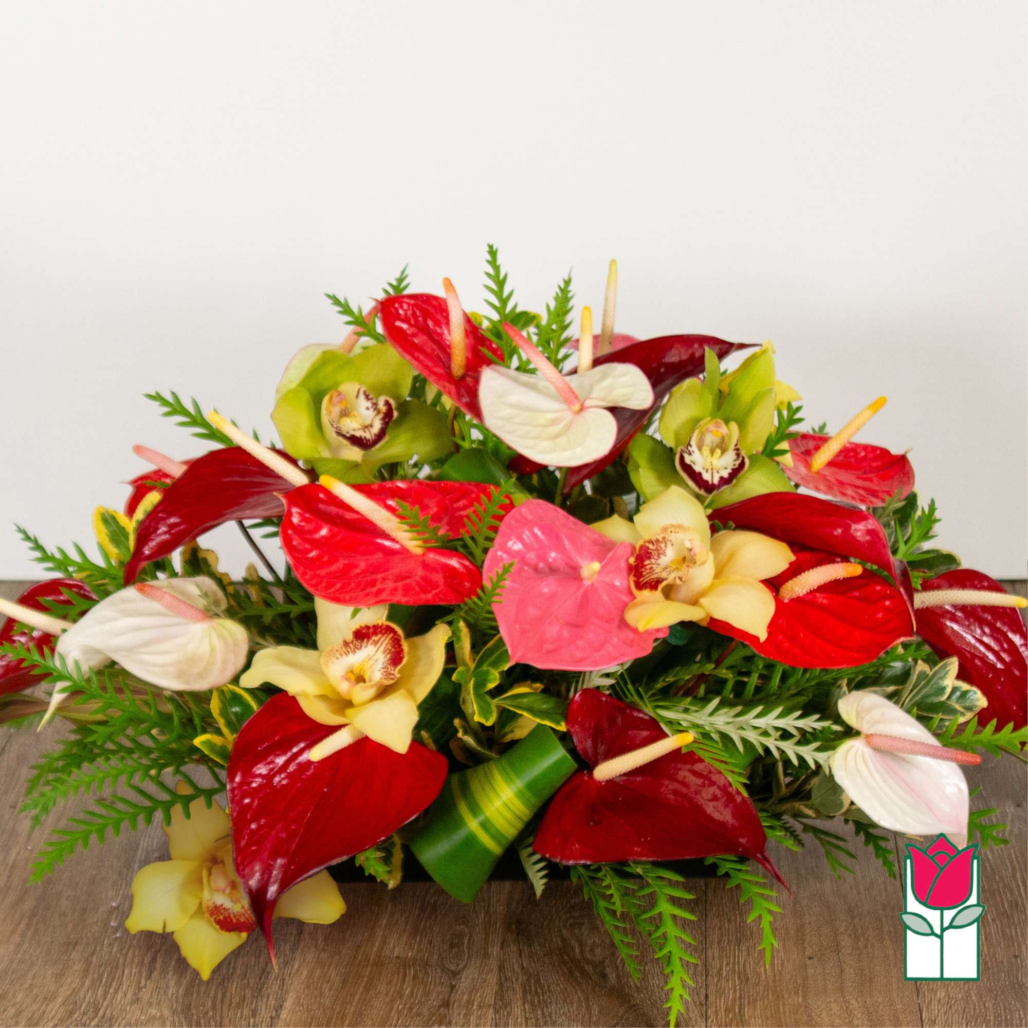 Tropical arrangement with red and white anthuriums and orchids
