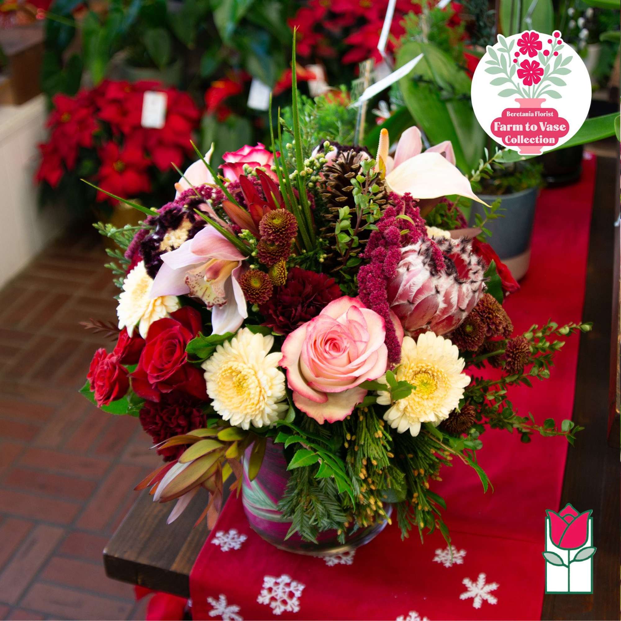 Mixed bouquet with pink roses, white daisies, and calla lilies in a glass vase