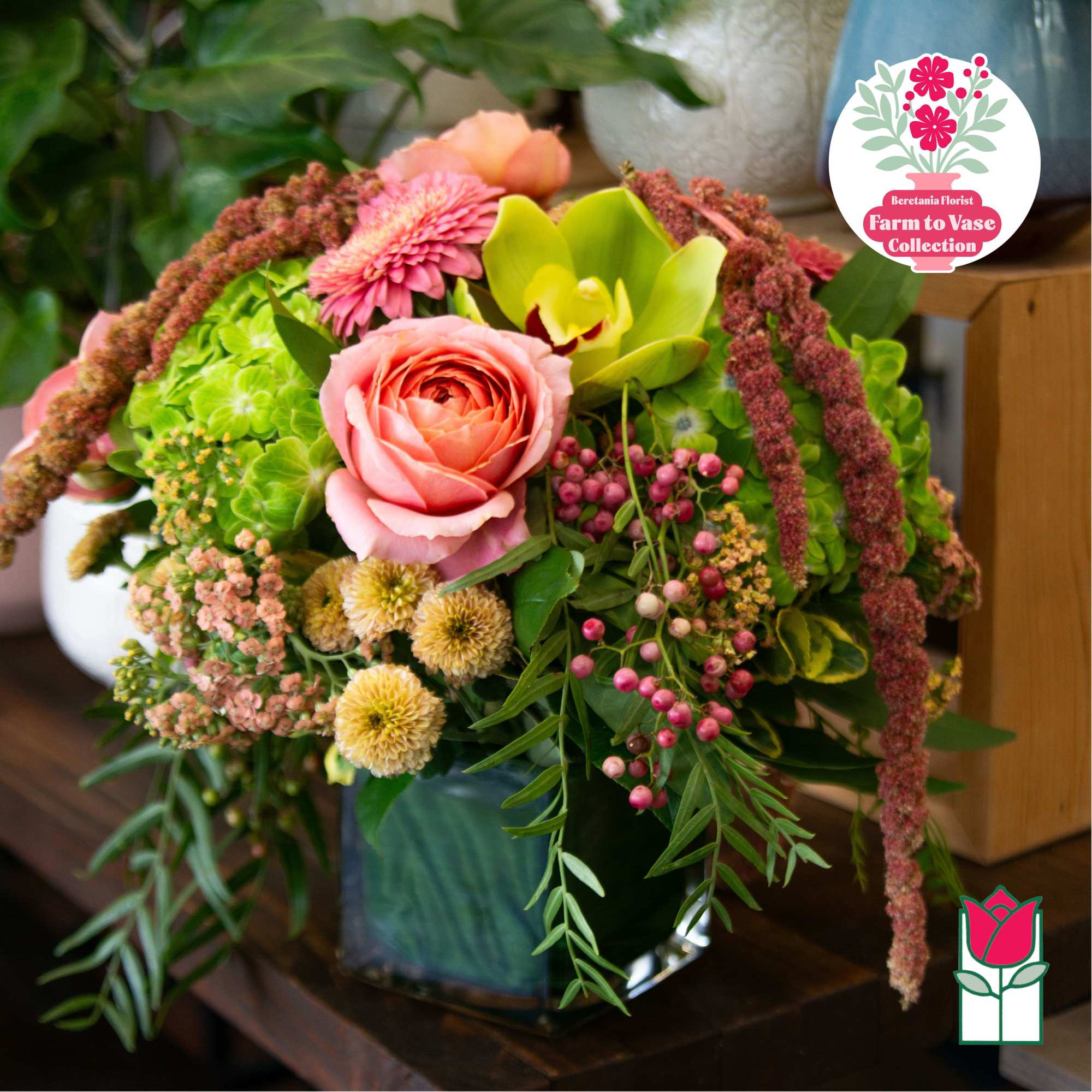 Mixed bouquet with pink roses, green hydrangea, and yellow orchids in a vase