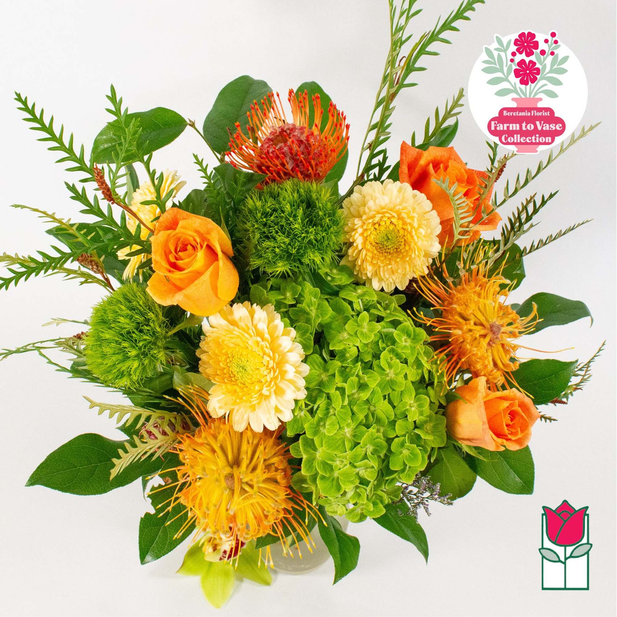 Orange roses and yellow blooms with green hydrangea in a vase