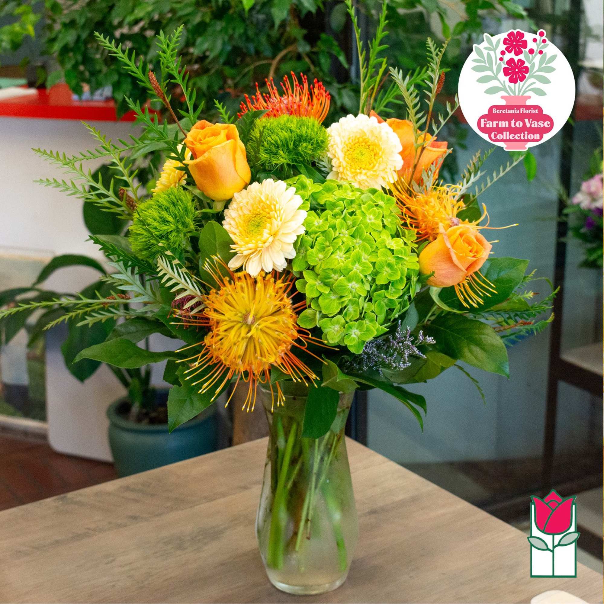 Orange roses and green hydrangea in a glass vase