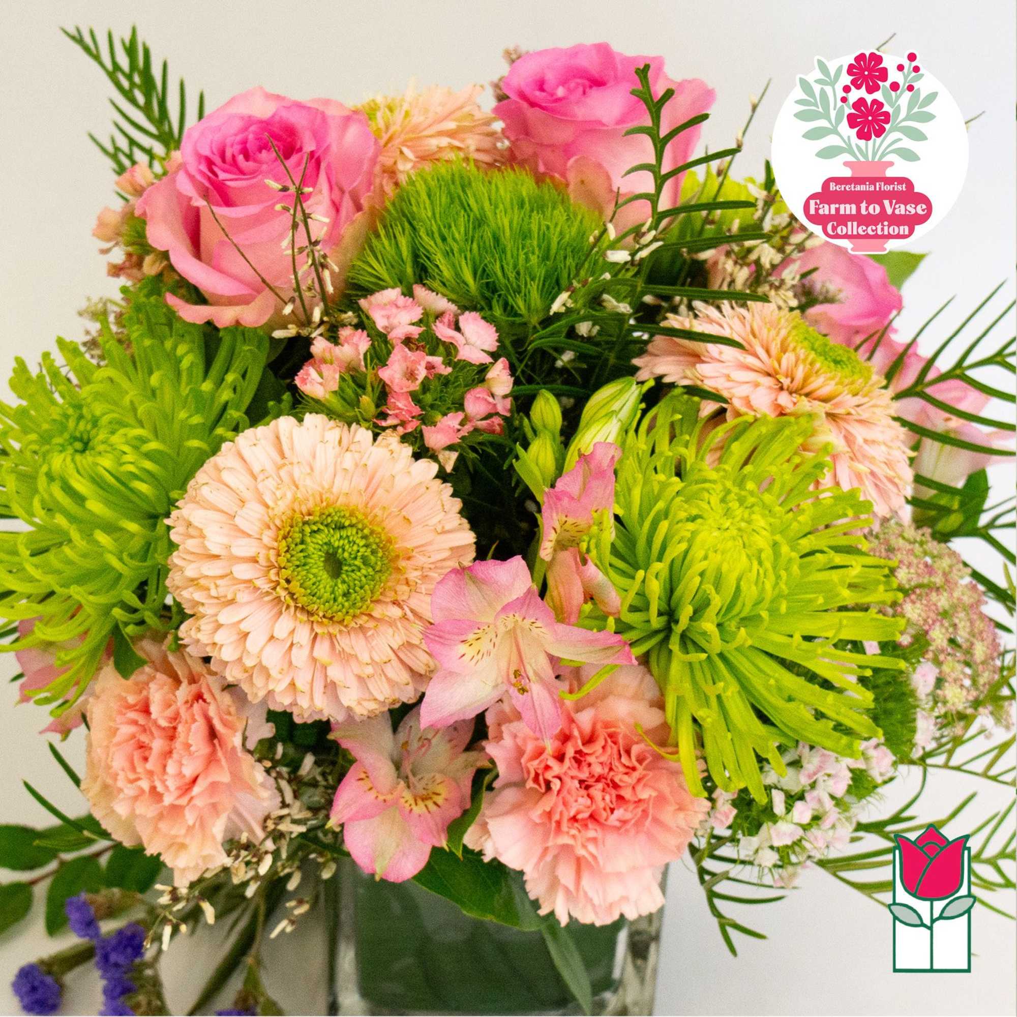 Pink and peach mixed bouquet with green spider mums in a glass vase