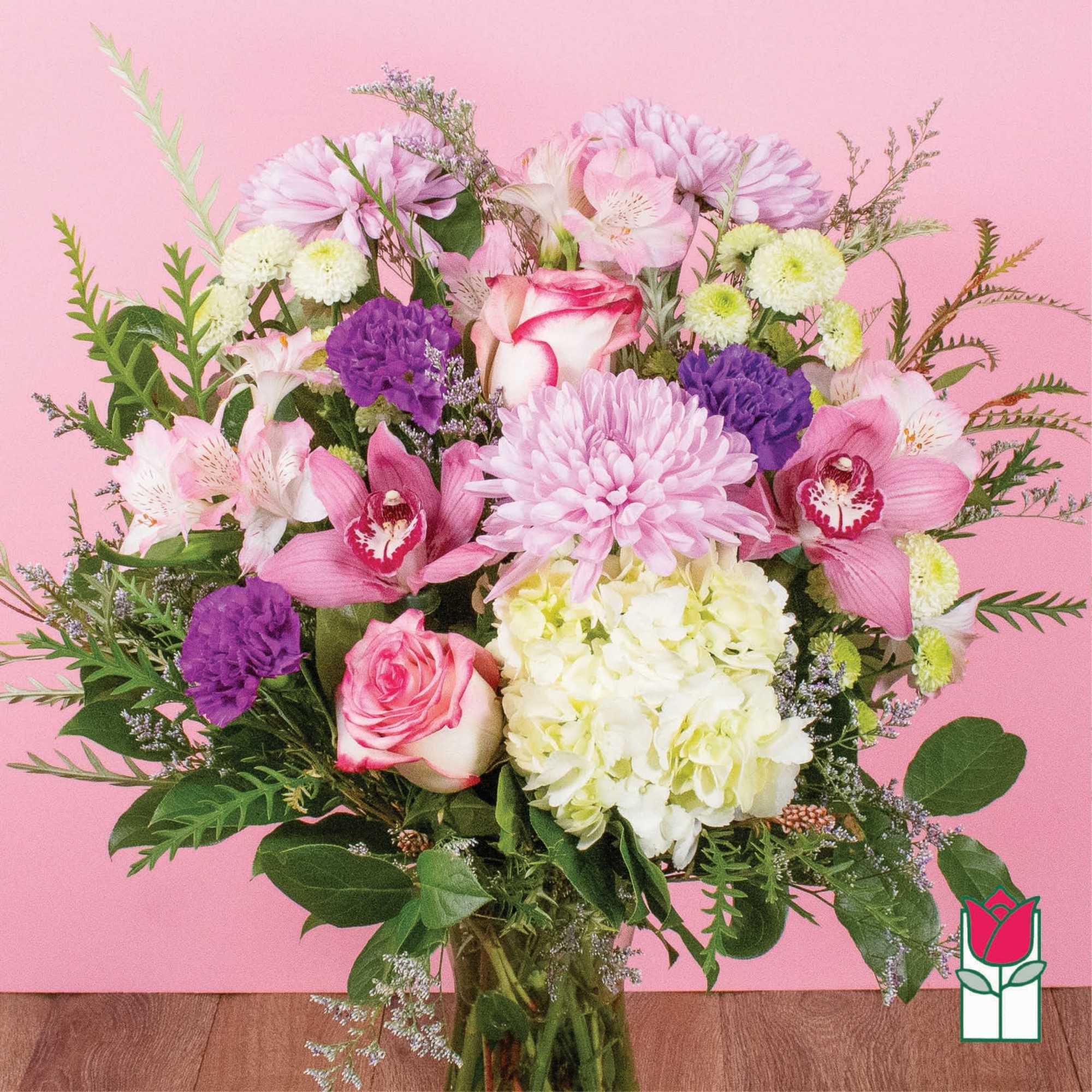 Mixed bouquet of pink, white, and purple flowers in a glass vase