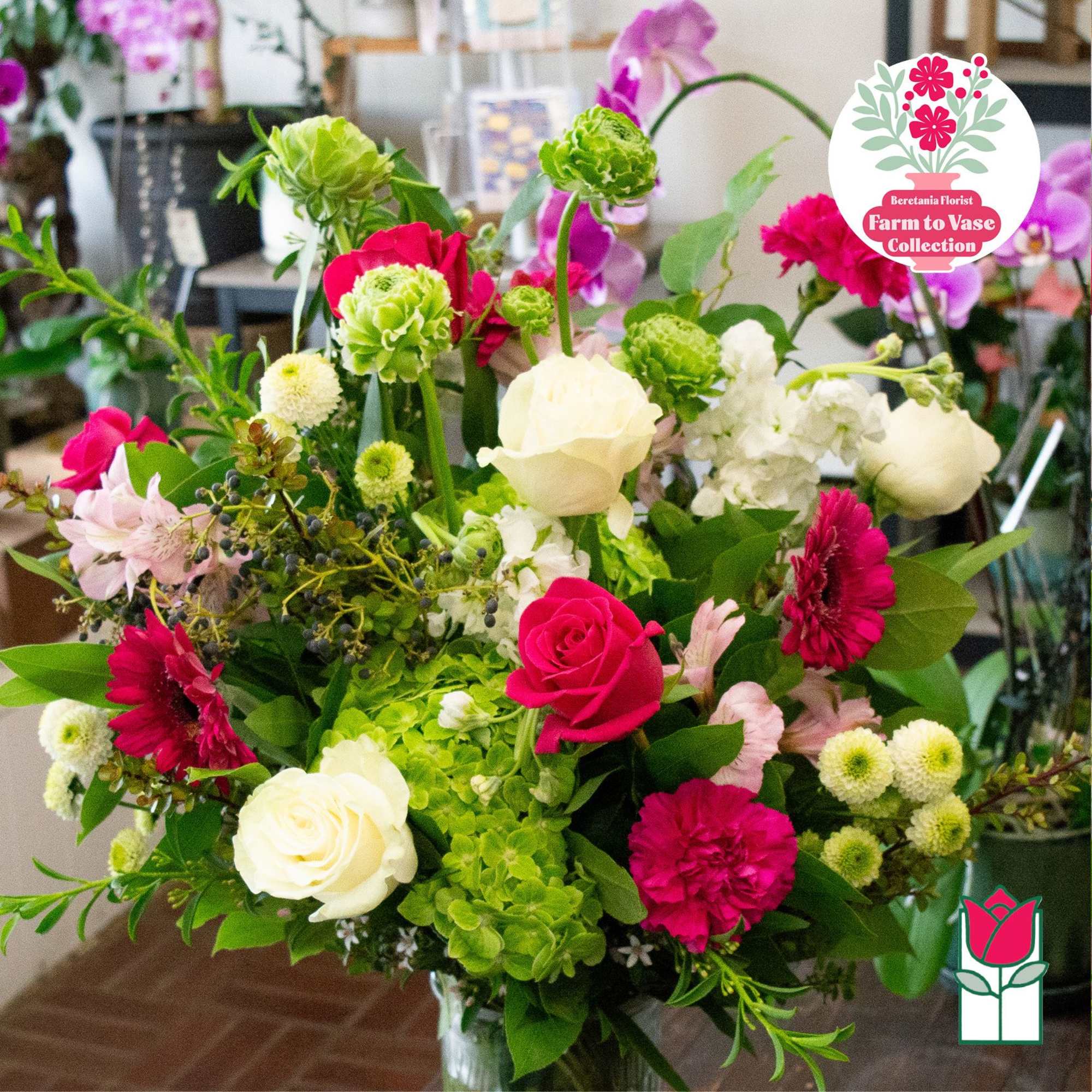 Mixed bouquet of pink, white, and green flowers in a glass vase