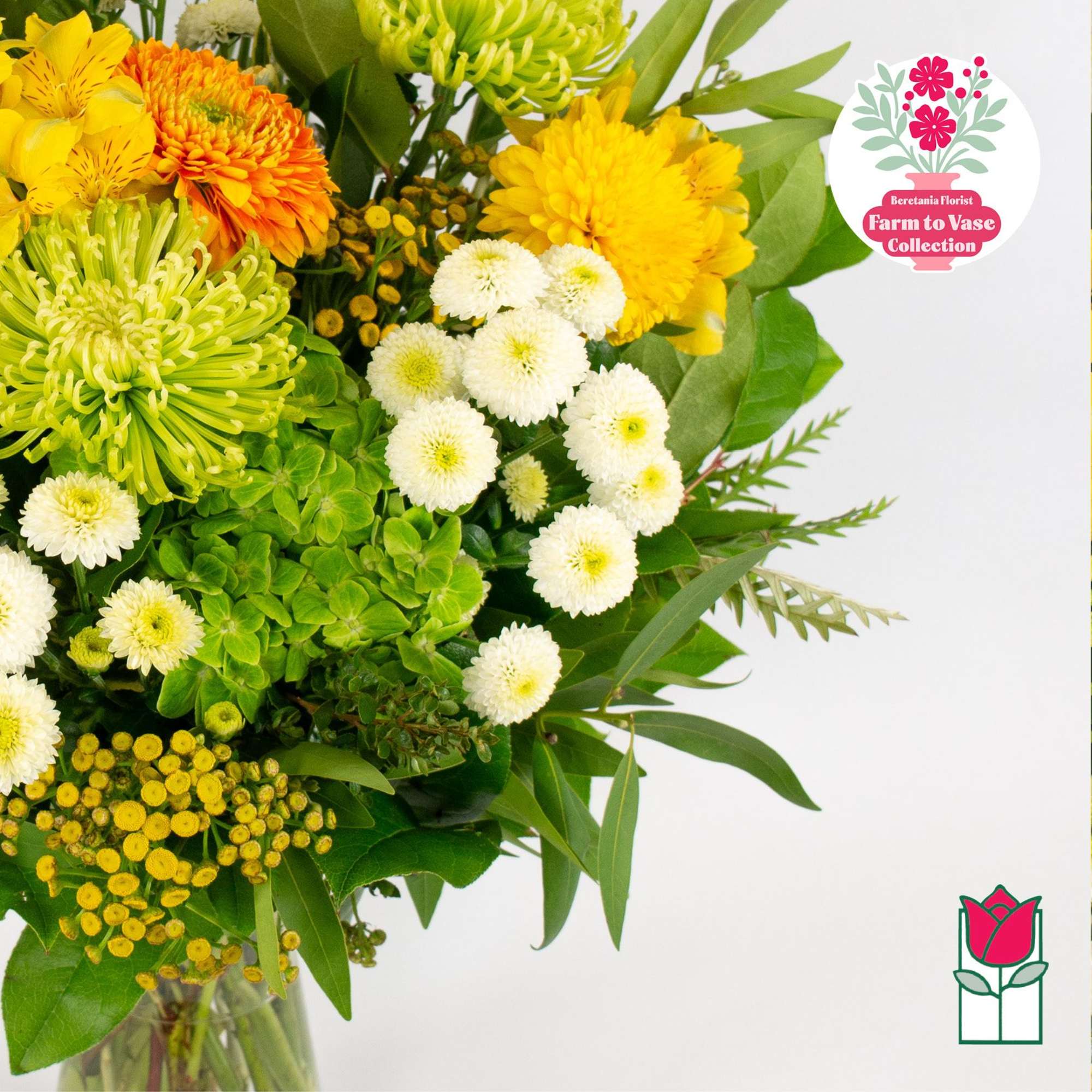 Bouquet of yellow, orange, white, and green flowers in a glass vase