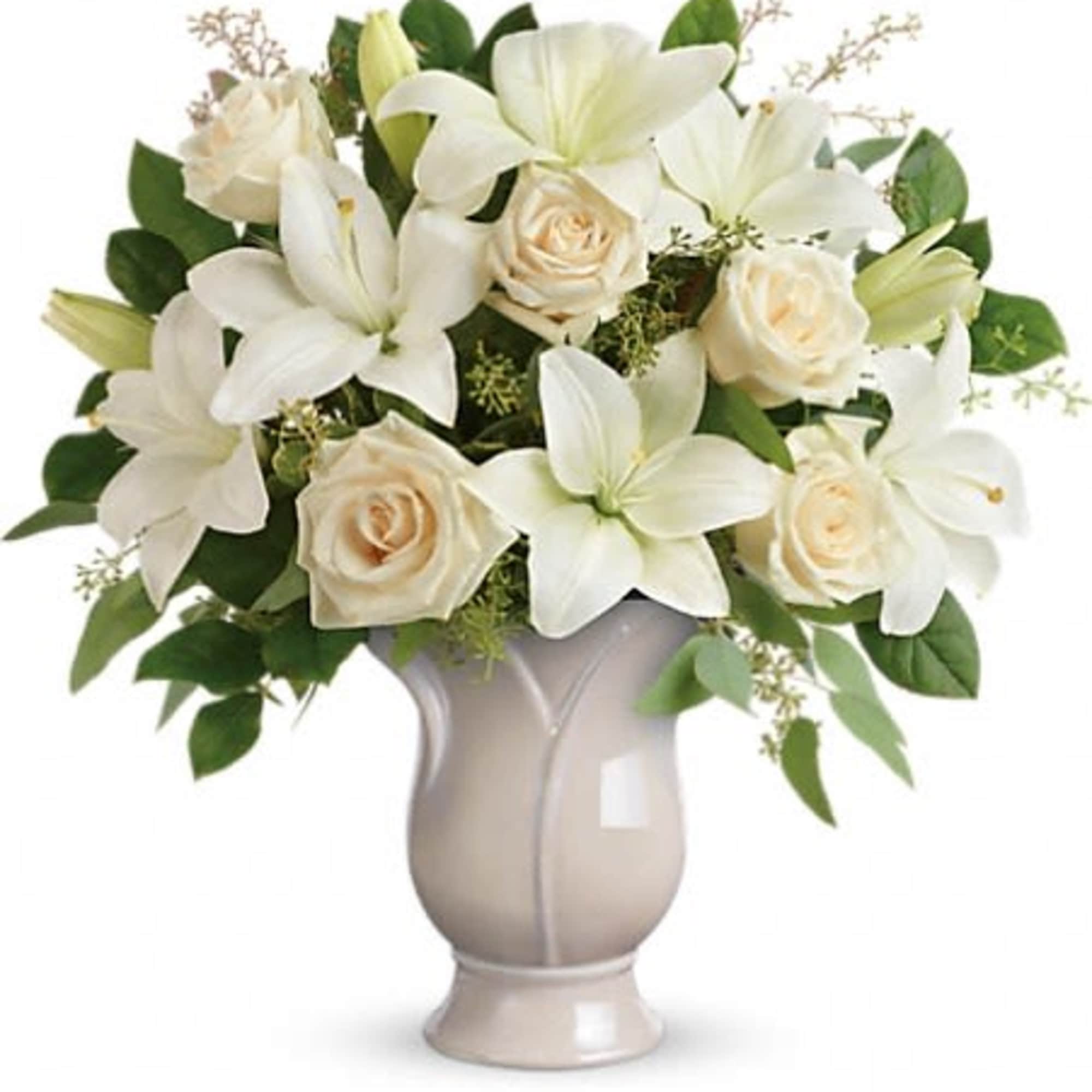 Arrangement of white lilies and cream roses in a pale ceramic pedestal vase