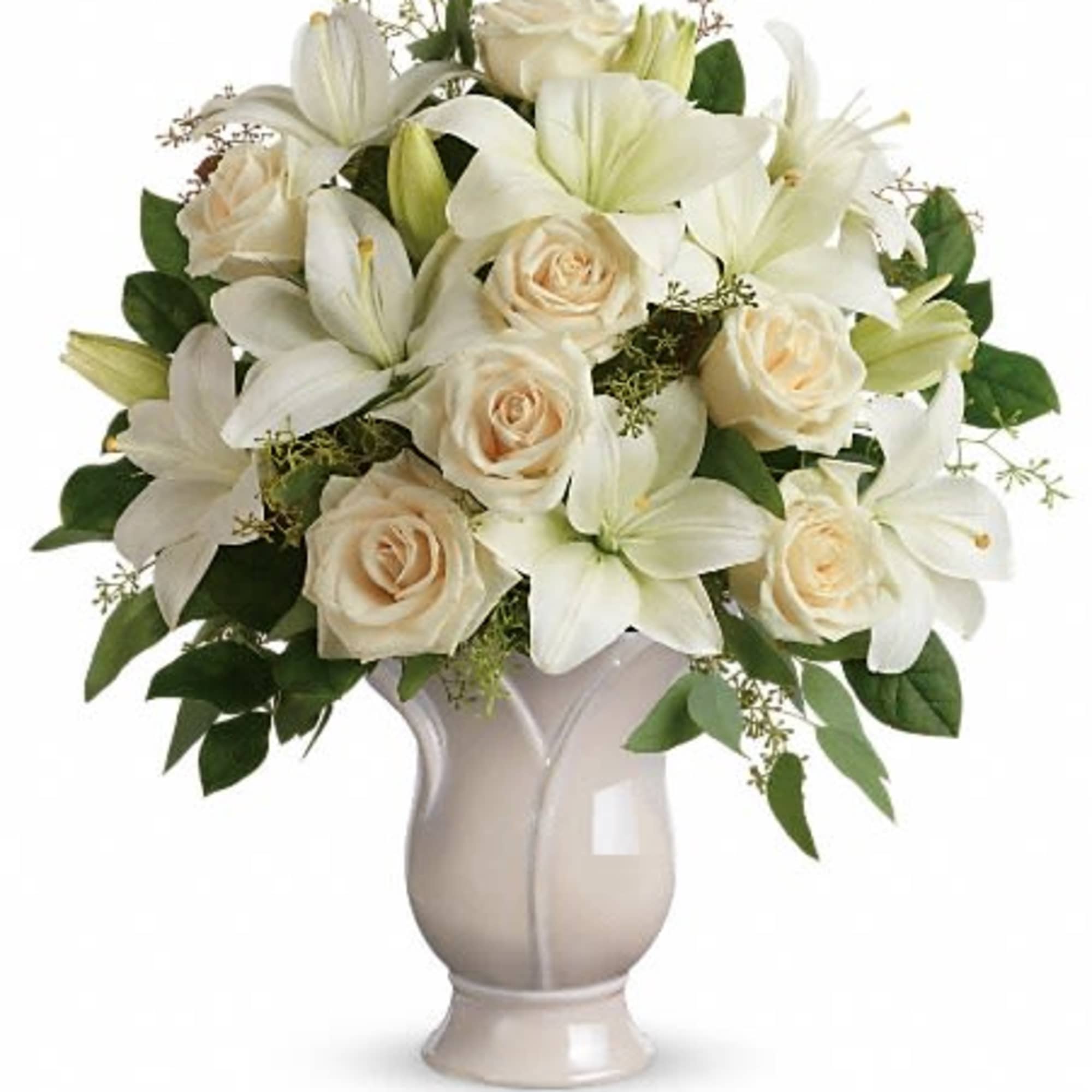 Arrangement of white lilies and cream roses in an ivory ceramic vase