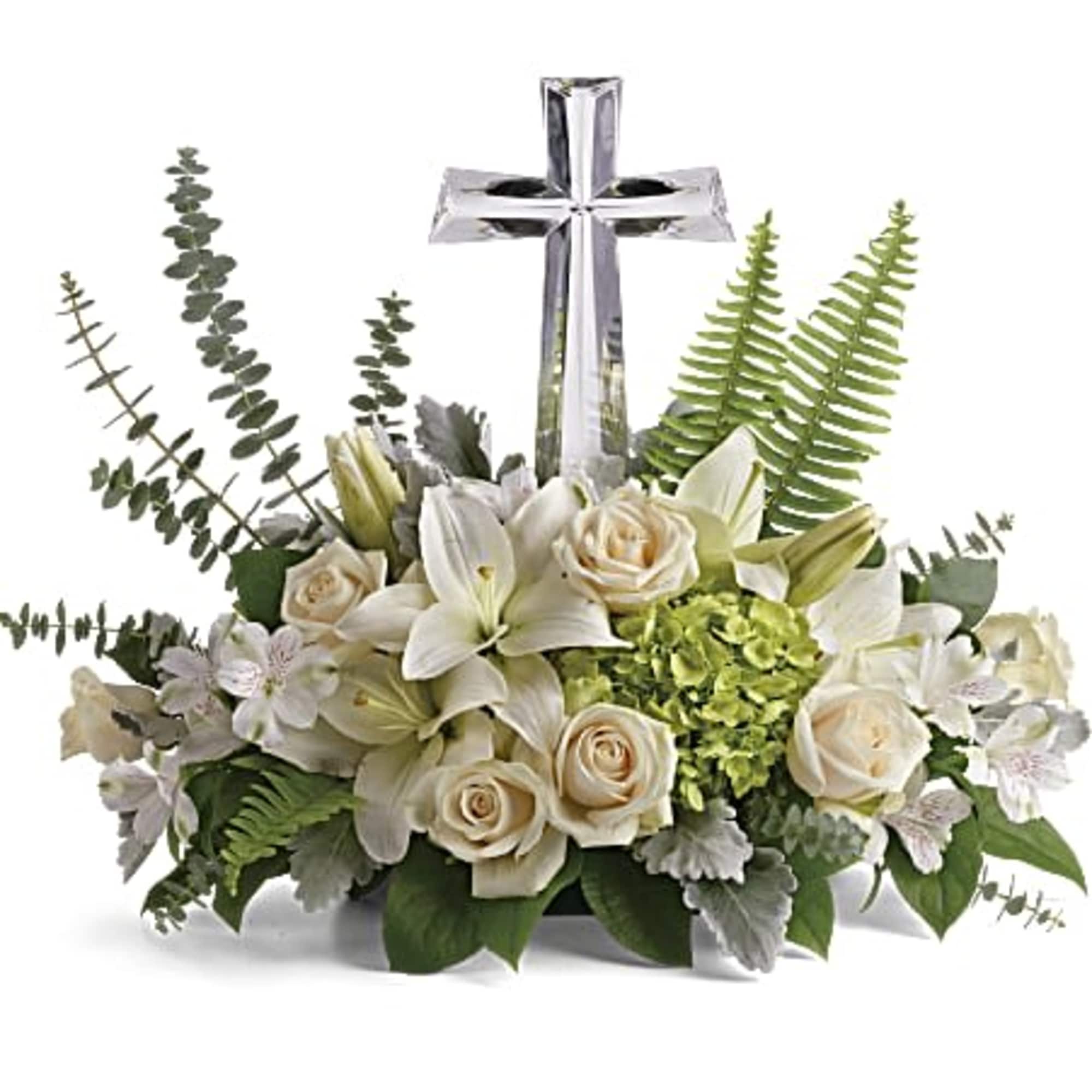 Low white lily and rose arrangement with green hydrangea and a clear crystal cross in the center