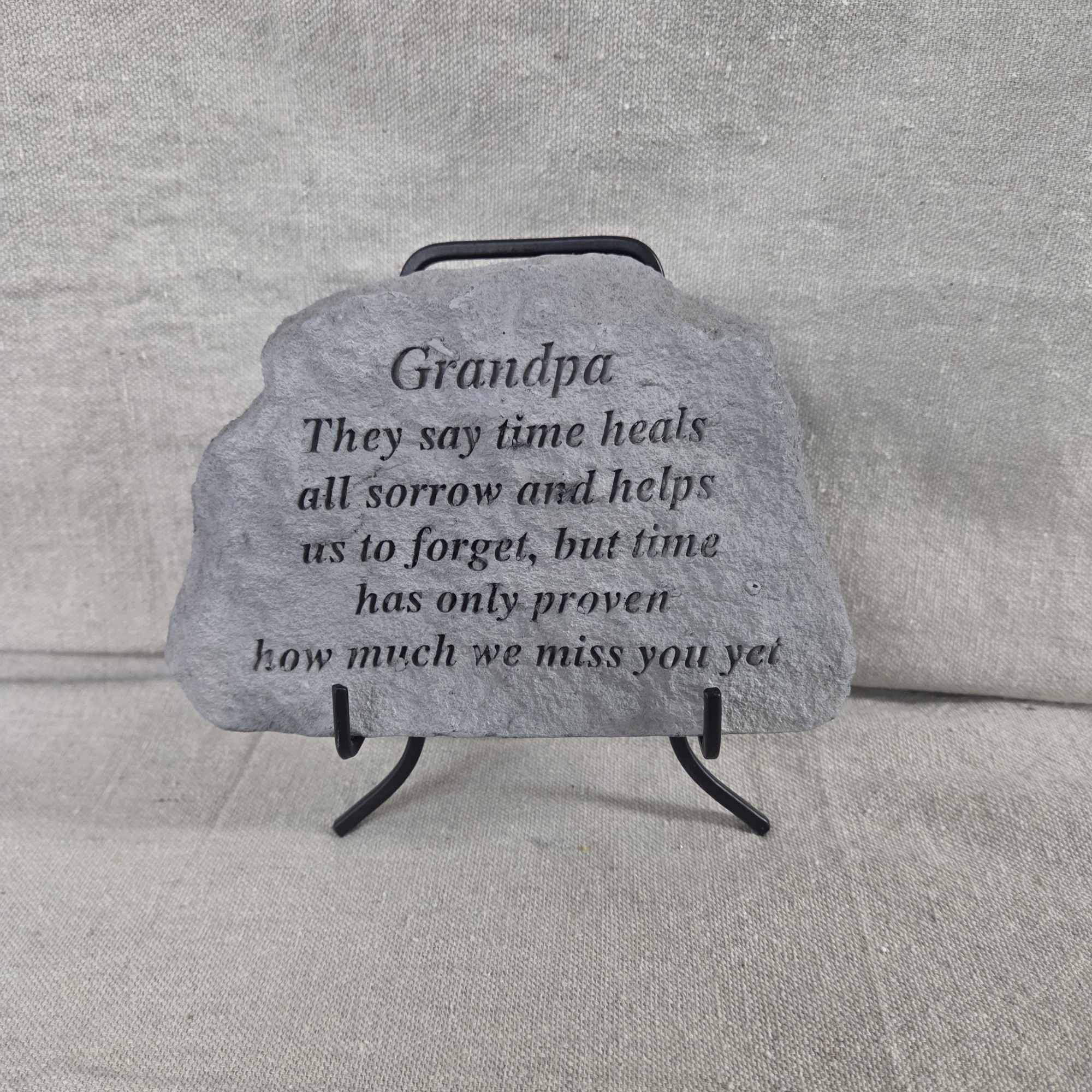 Gray stone memorial plaque for Grandpa with engraved verse on a small black metal stand.