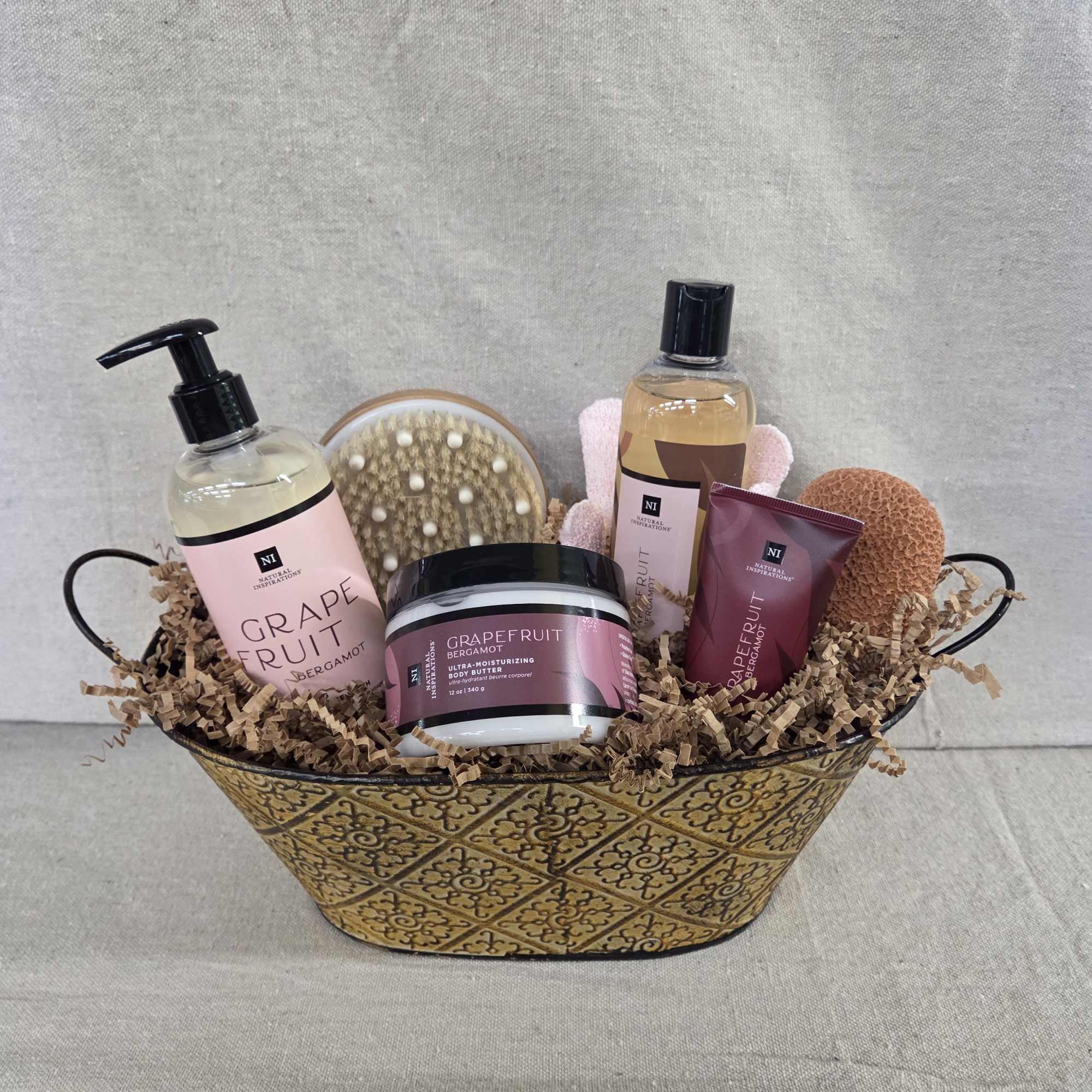 Grapefruit-scented bath and body gift set in a patterned metal basket with brush and sponges