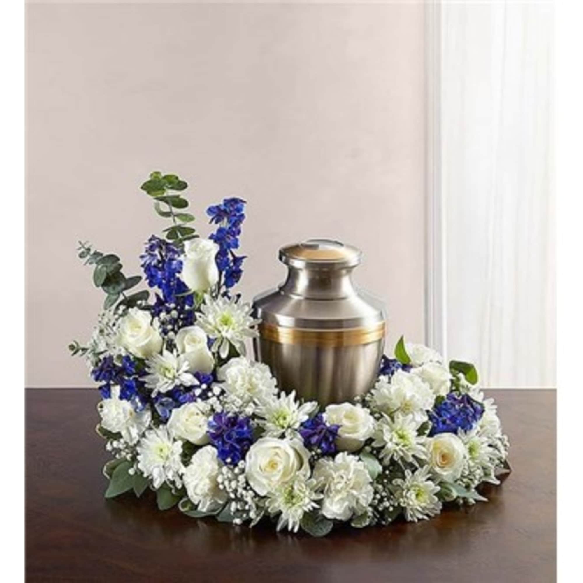 White and blue floral wreath around a metal urn