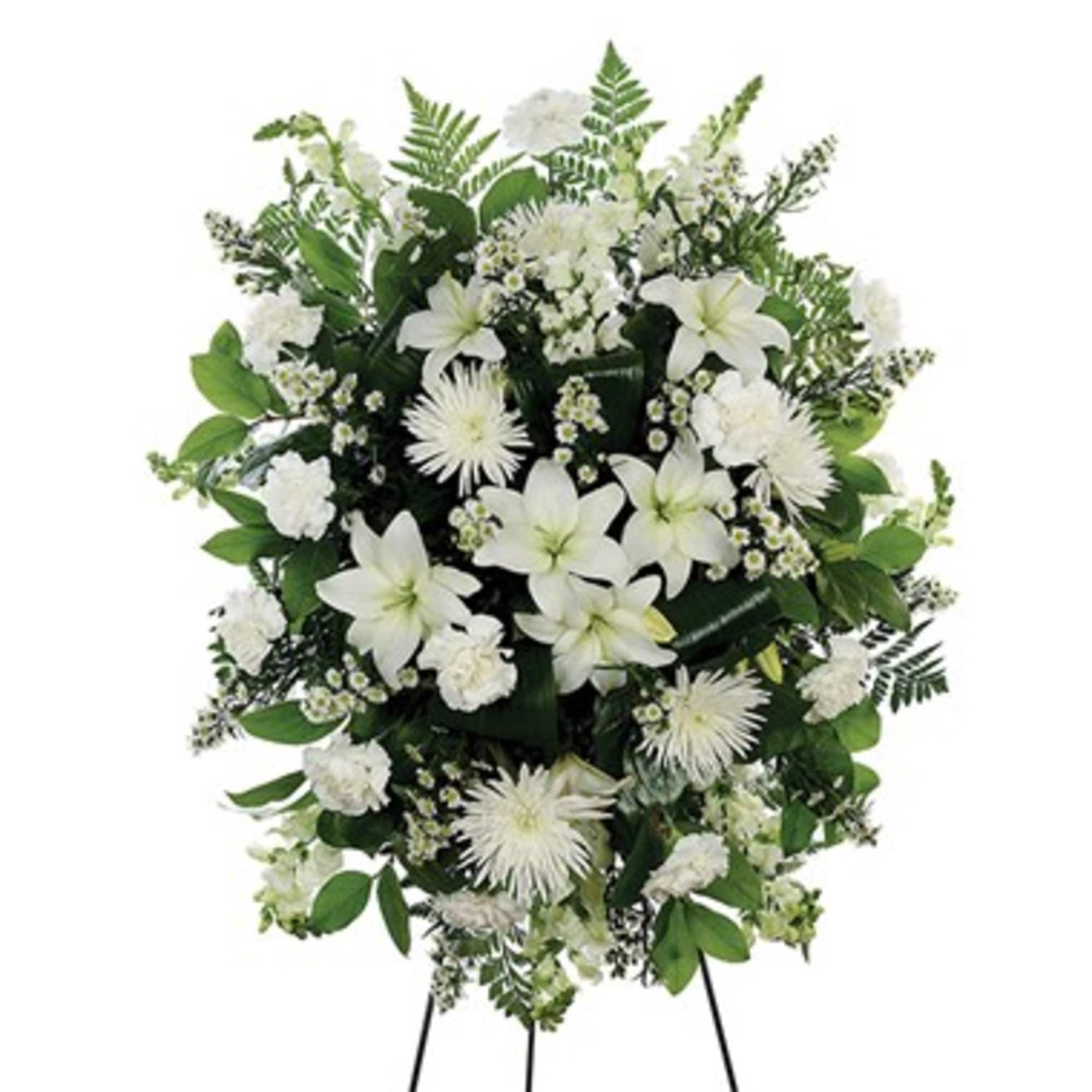 White funeral spray with lilies and chrysanthemums on a standing easel