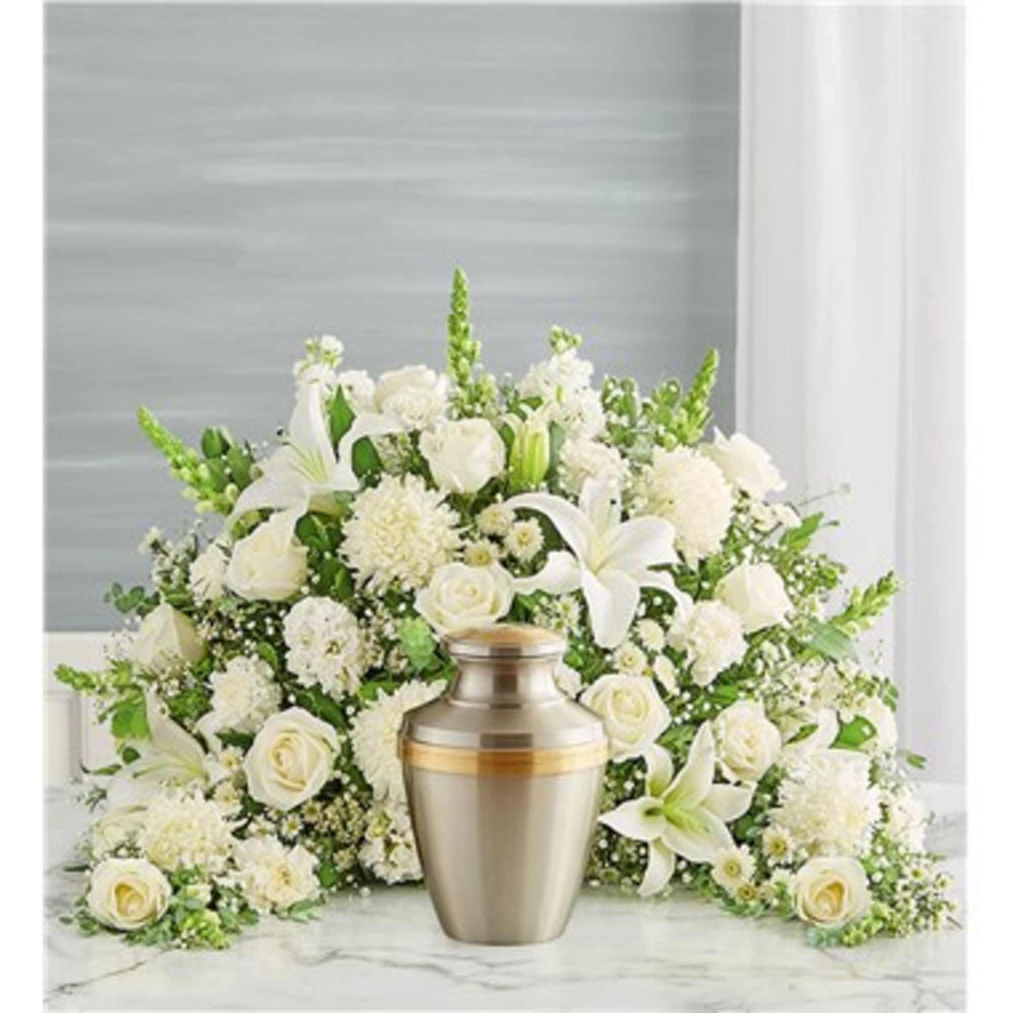 White floral funeral arrangement with a gold urn centerpiece