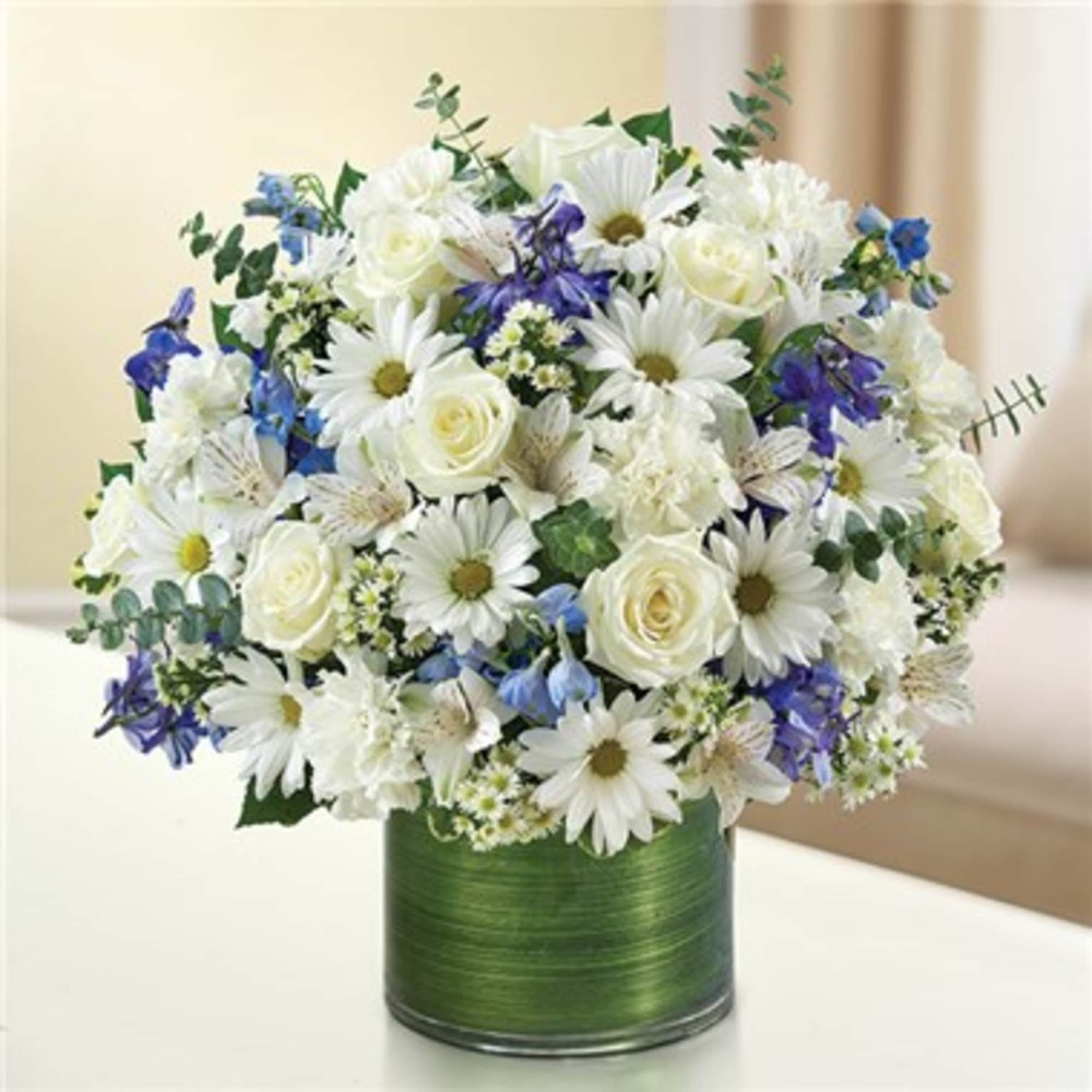 White daisies and roses in a green vase with blue accents