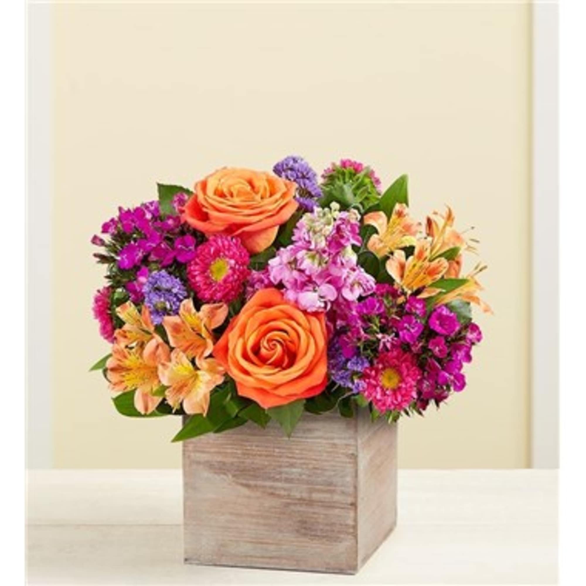 Orange roses and mixed purple flowers in a wooden box