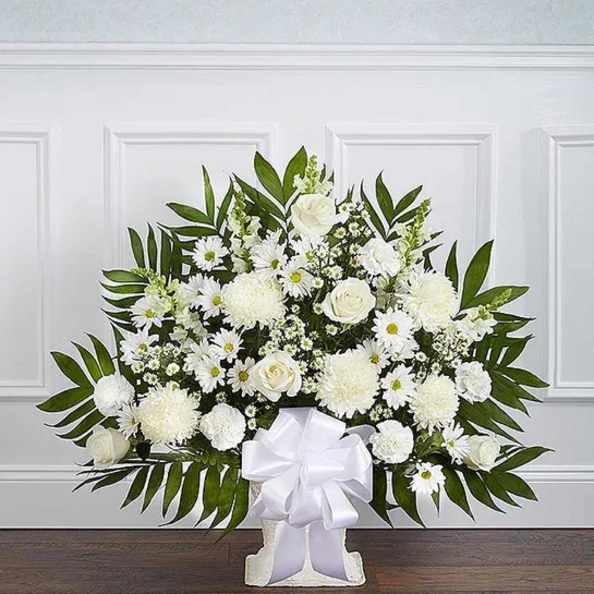 White floral standing spray with a large ribbon bow