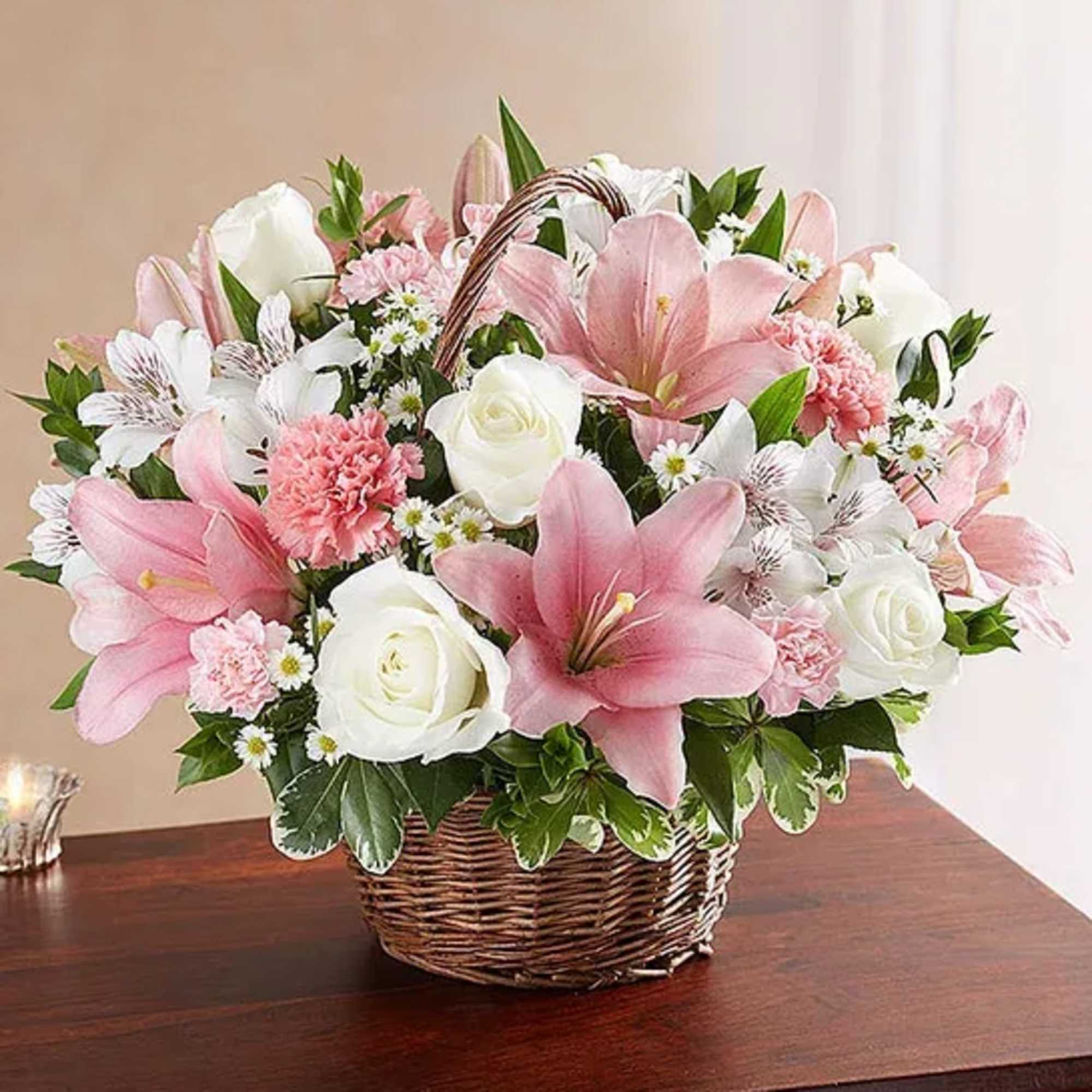 Pink lilies and white roses in a wicker basket