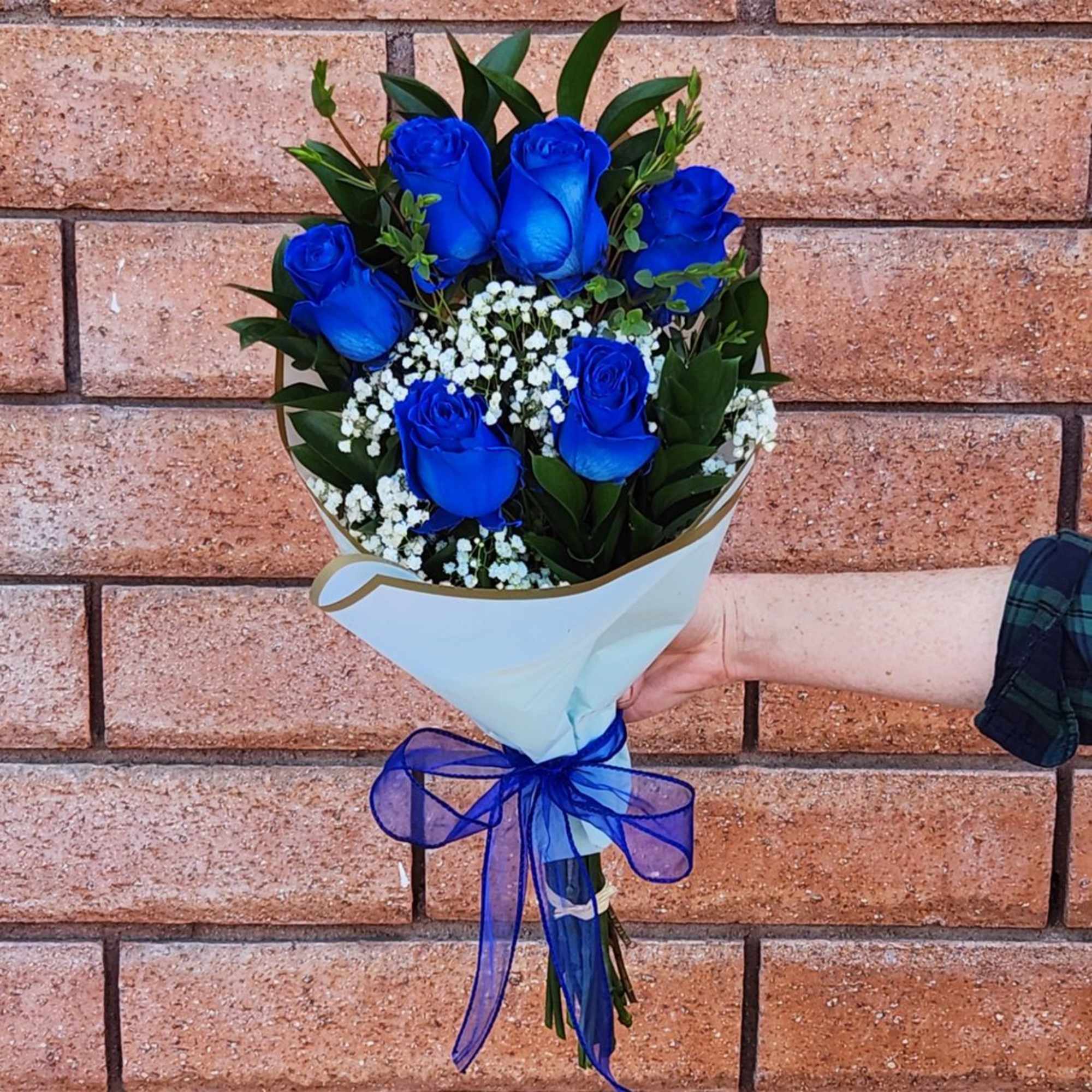 Bouquet of blue roses with white baby's breath and a blue ribbon