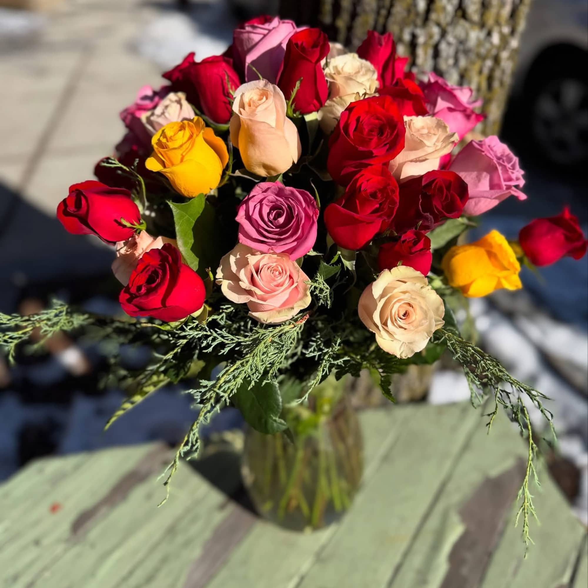 Bouquet of multicolored roses in a clear glass vase