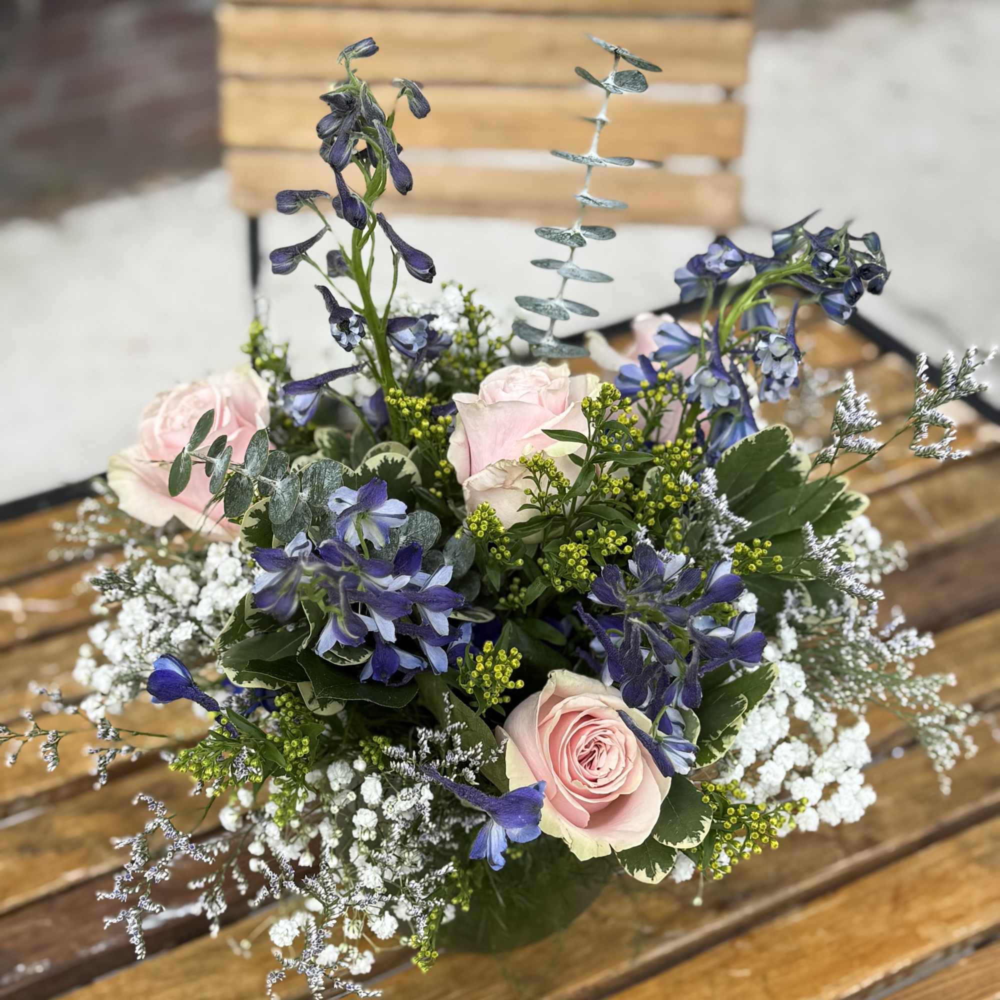 A beautiful combination of pastel pinks and blue blooms arranged with stock