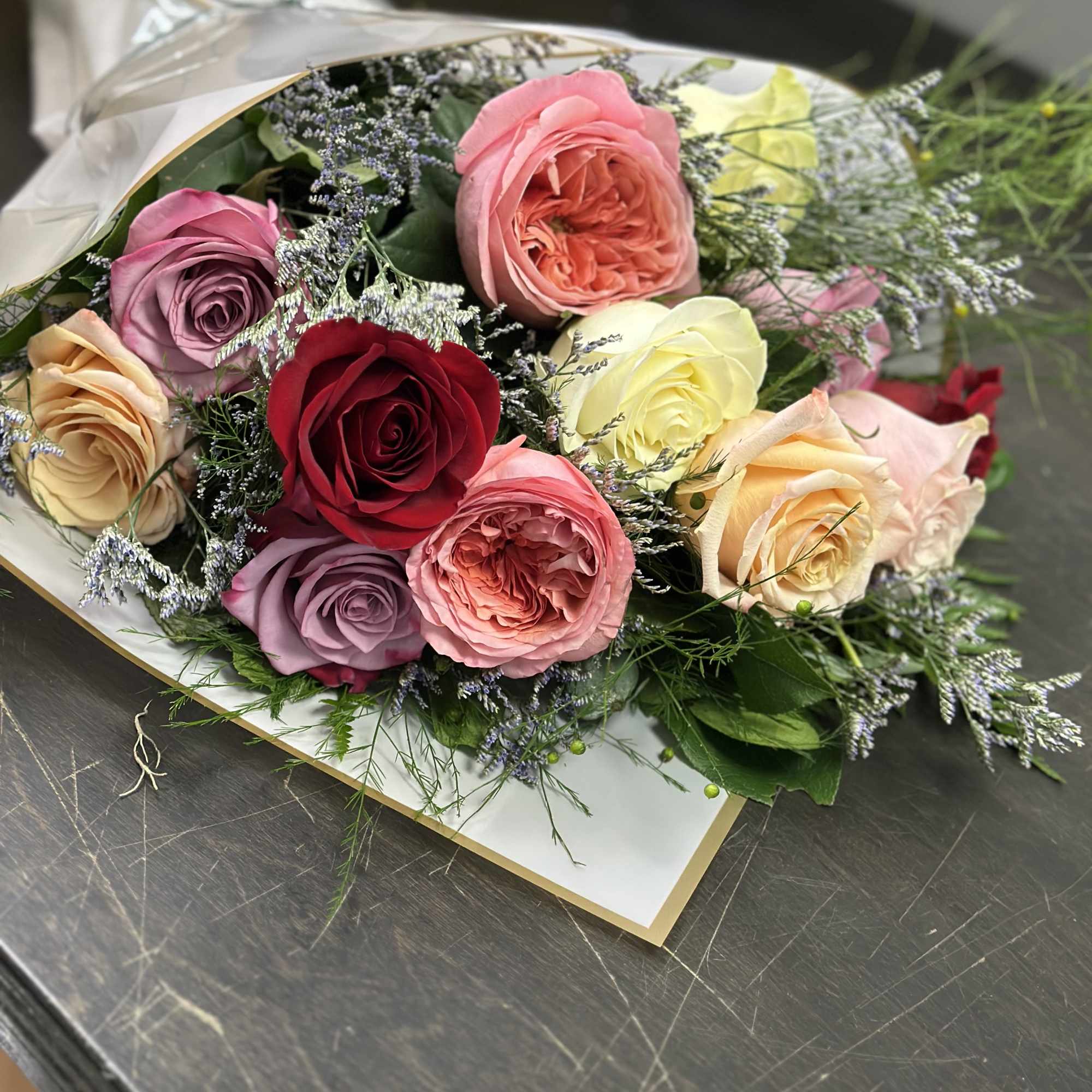 Bouquet of multicolored roses wrapped in clear paper, photo 2 of 2