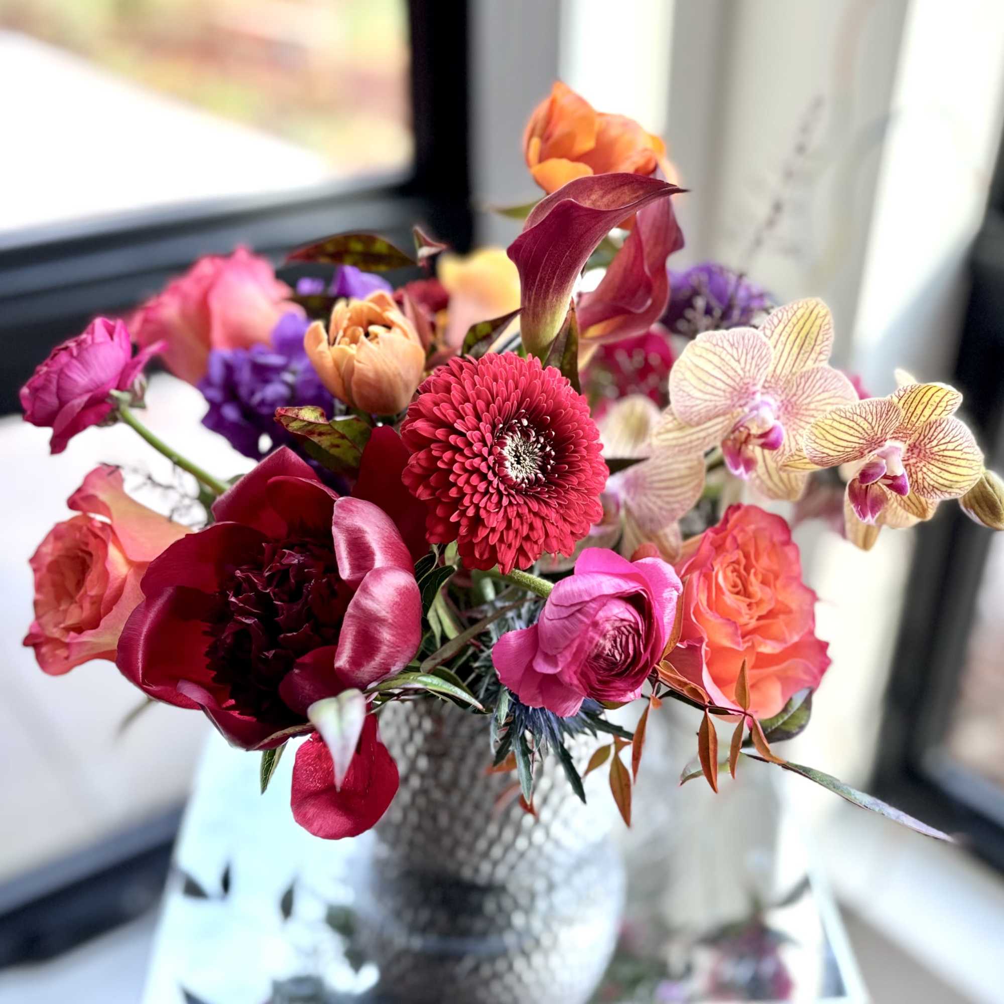 Cute colorful flower arrangement of premium flowers in a silver Supernova Pot