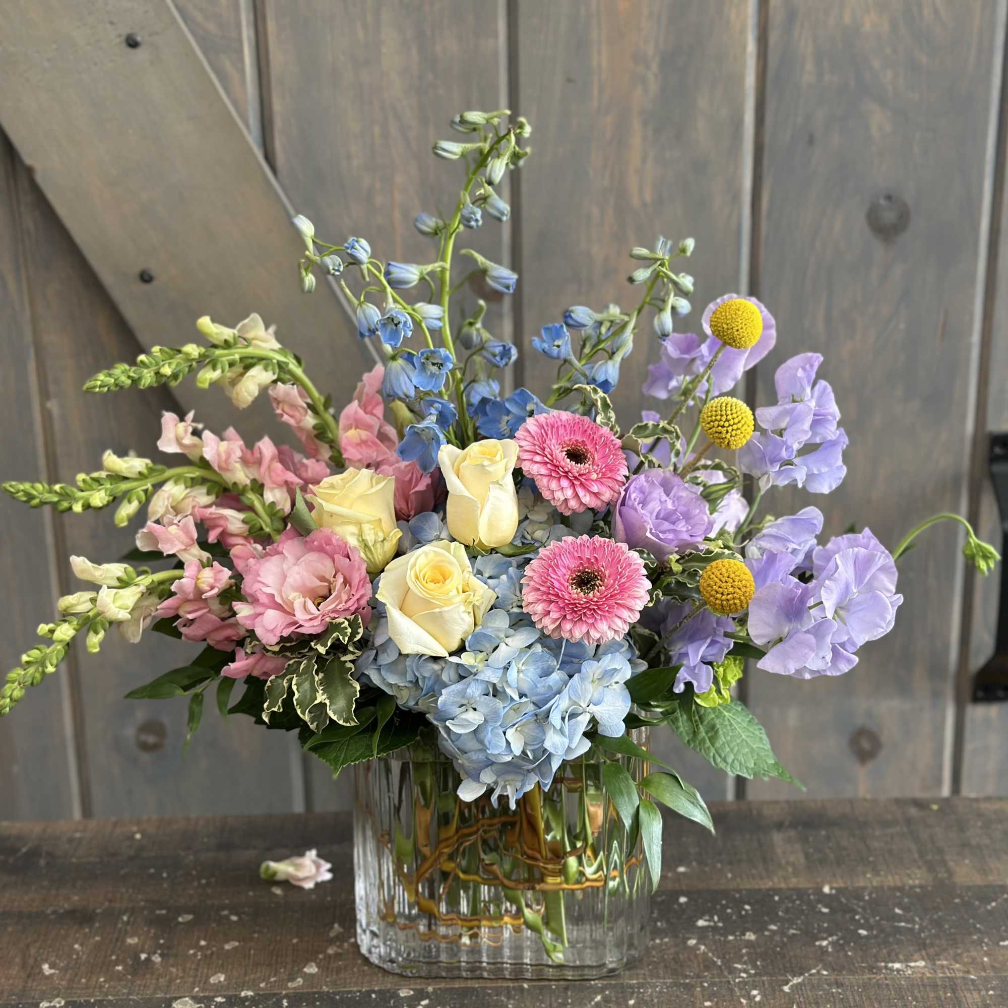 This fun and spring inspired arrangement includes Roses, hydrangea, Mini hydrangea, Sweet