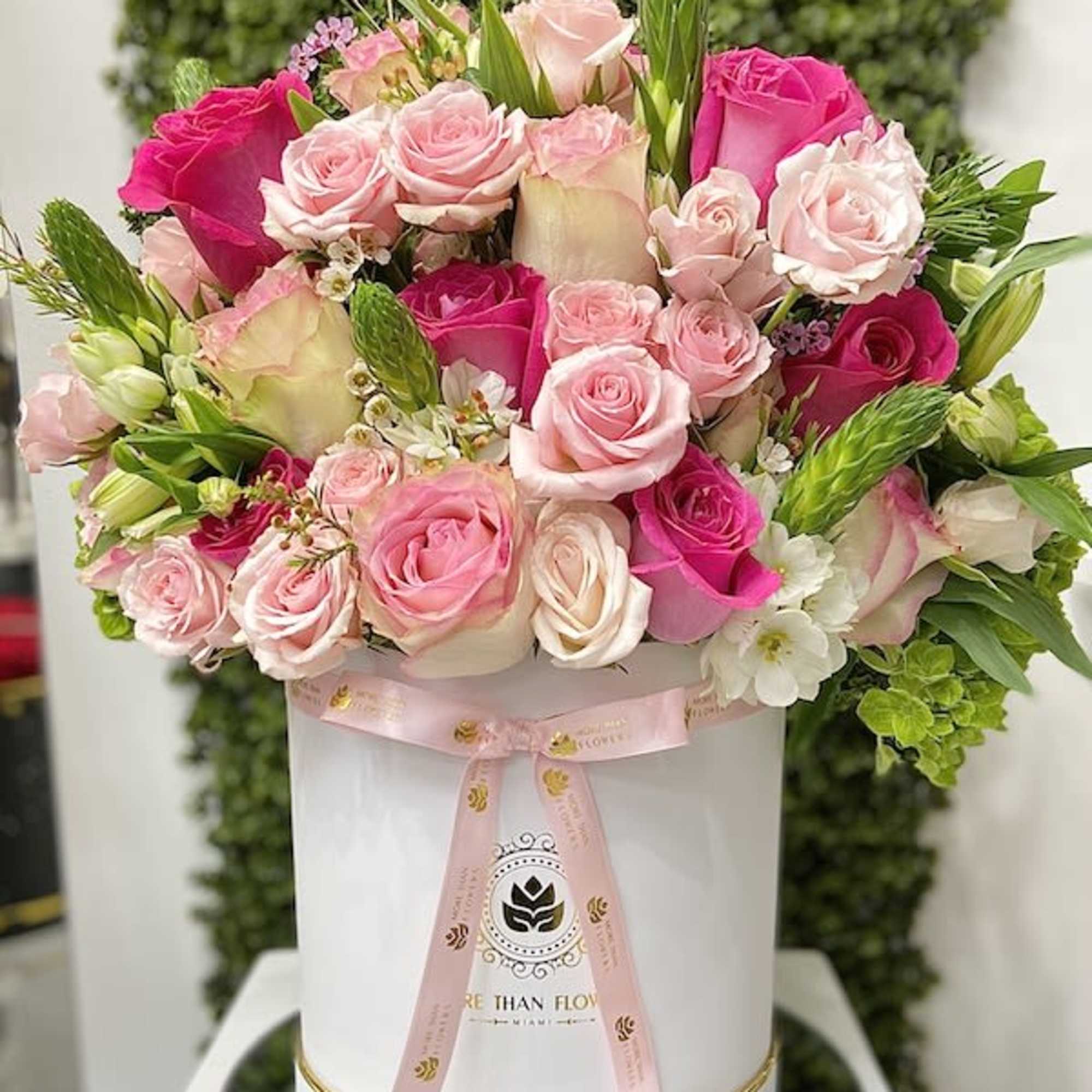 Round hatbox arrangement of pink and white roses in a white cylinder box tied with a pink ribbon