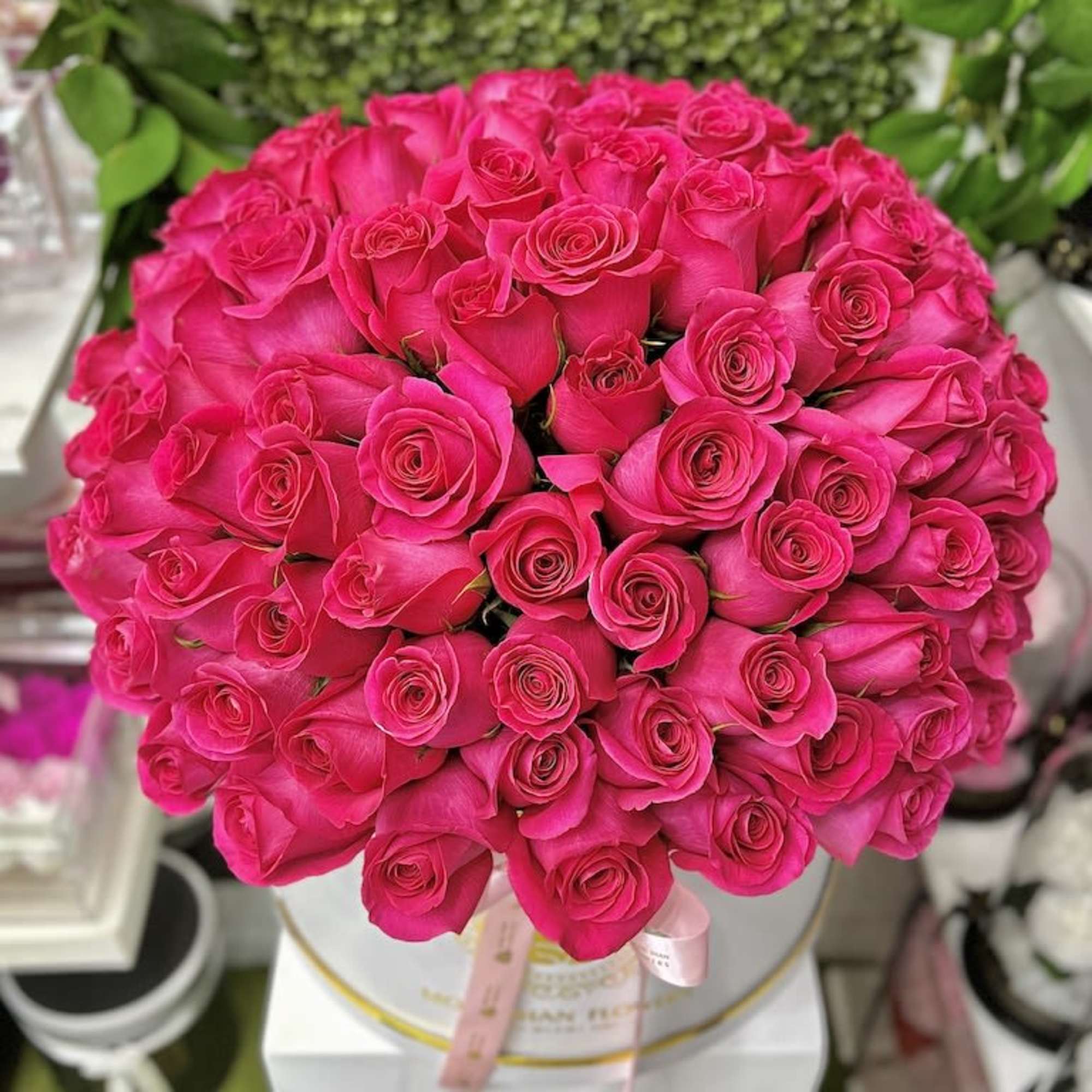 Large round hatbox filled with hot pink roses