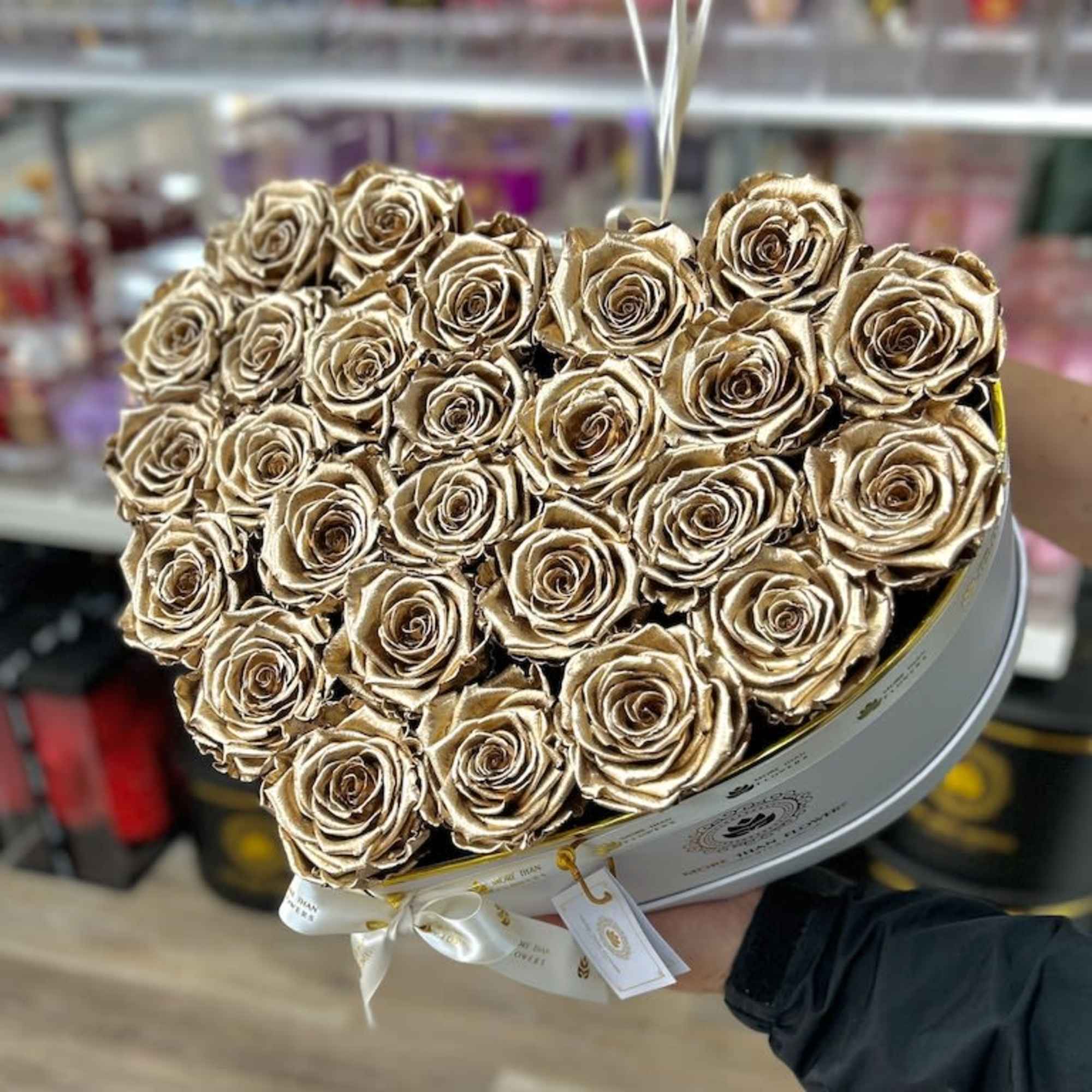 Heart-shaped arrangement of metallic gold roses in a white hatbox-style container
